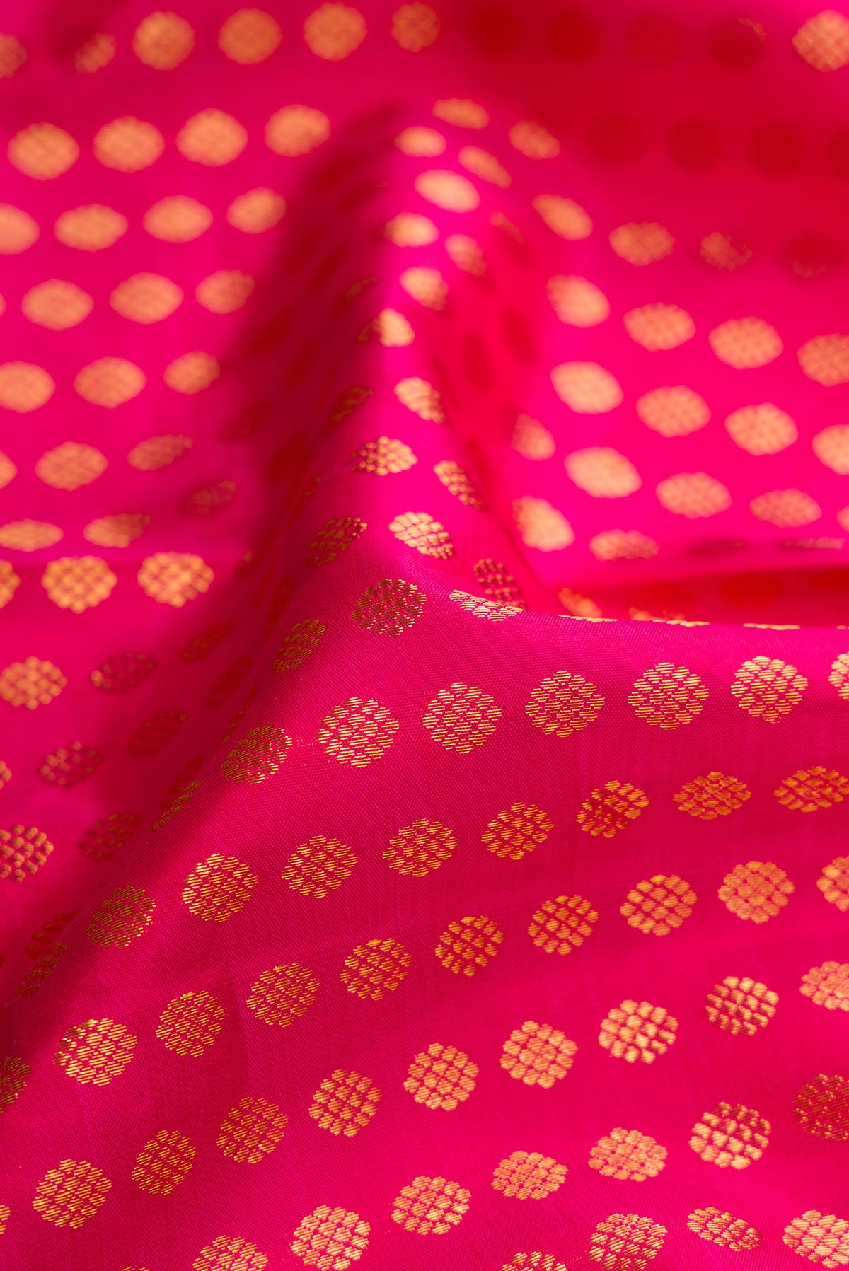 Close up of Pink Dual Tone Kanchipuram Silk Saree with Zari Butta on the body and Zari Border.  displaying folds