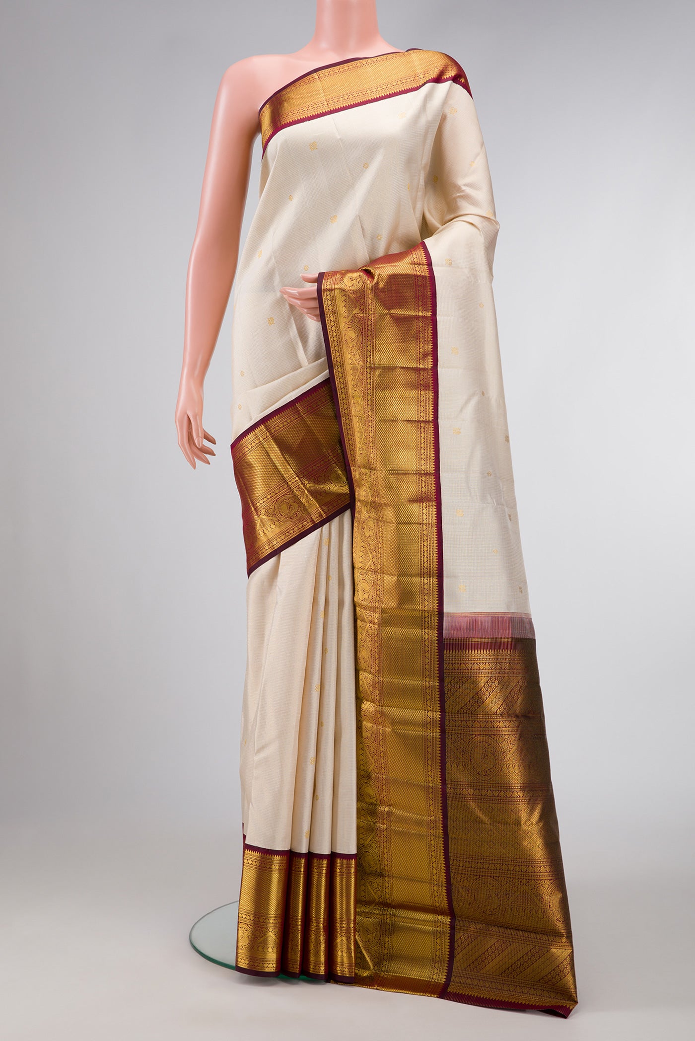 Beige Dual Tone Kanchipuram Silk Saree with Zari Butta on the body and Zari Border.  displayed on a mannequin