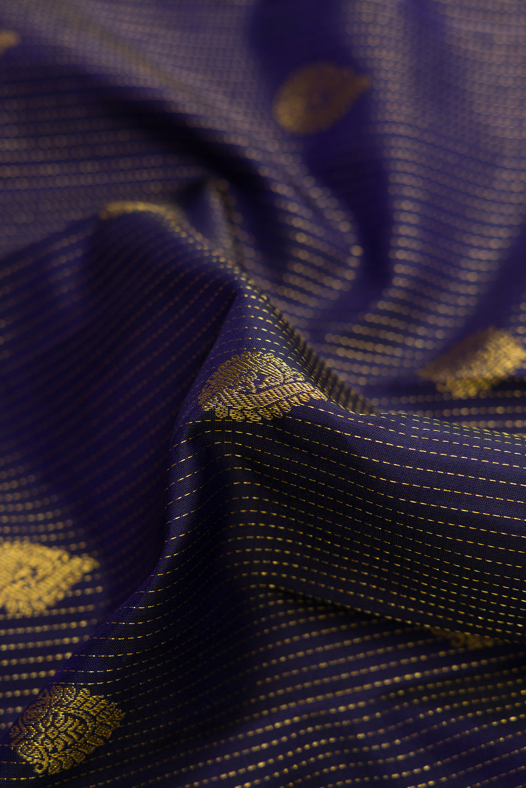 Close up of Navy Blue Dual Tone Kanjivaram Silk Saree with Zari Butta on the body and Zari Border.  displaying folds