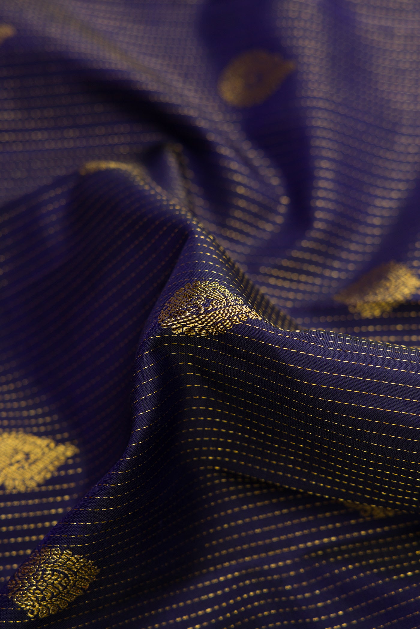 Close up of Navy Blue Dual Tone Kanjivaram Silk Saree with Zari Butta on the body and Zari Border.  displaying folds