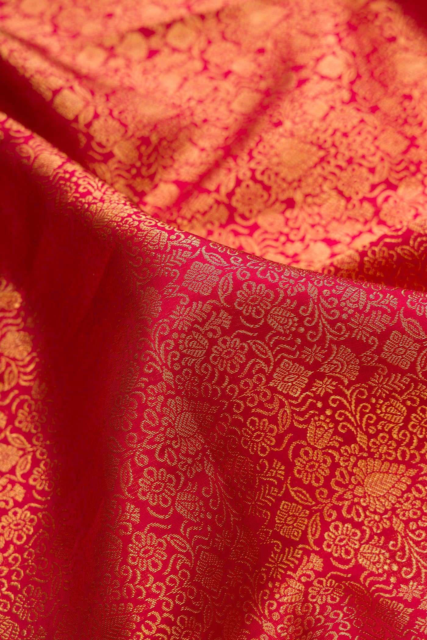 Close up of Dark Pink Dual Tone Kanchipuram Silk Saree with Zari Brocade on the body and Zari Border.  displaying folds