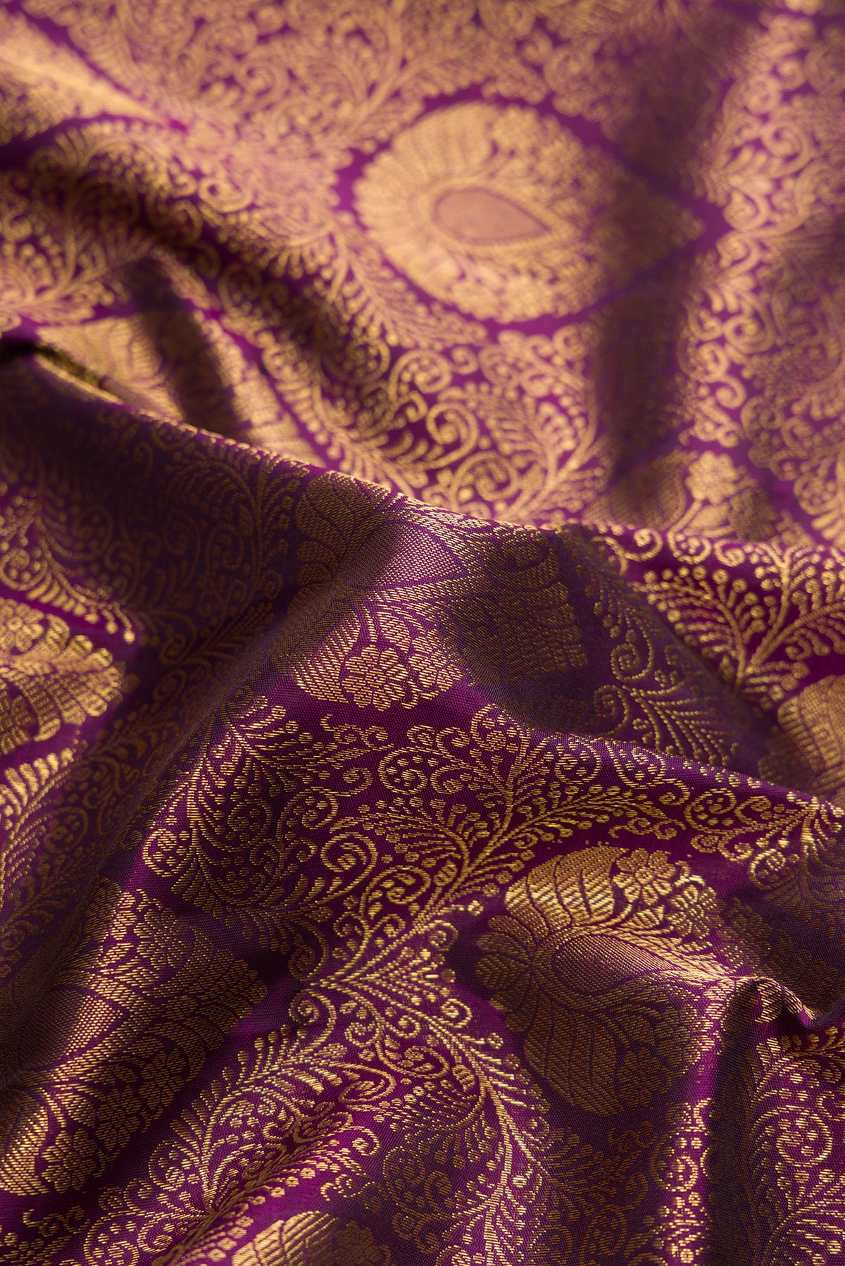Close up of Burgundy Dual Tone Kanjivaram Silk Saree with Zari Brocade on the body and Zari Border.  displaying folds