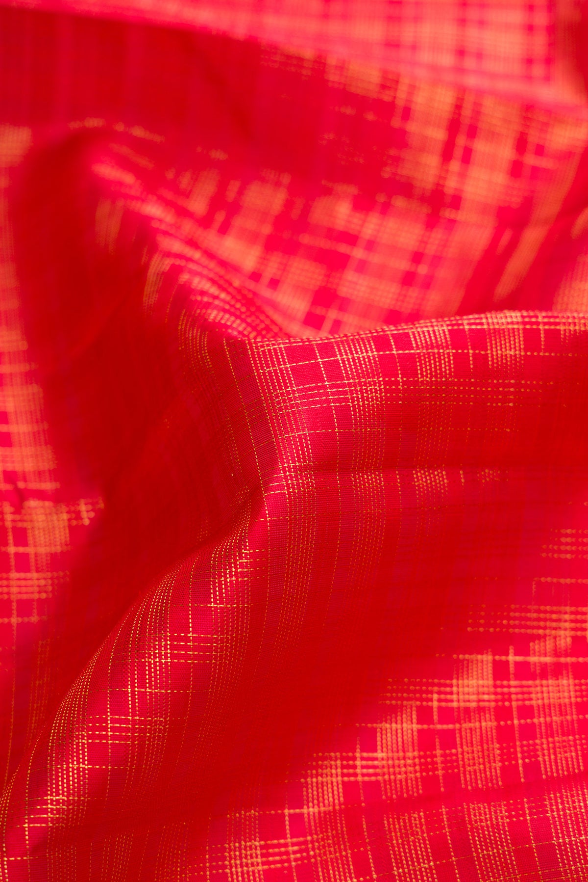 Close up of Red Dual Tone Kanjivaram Silk Saree with Checked design on the body and Zari Border.  displaying folds