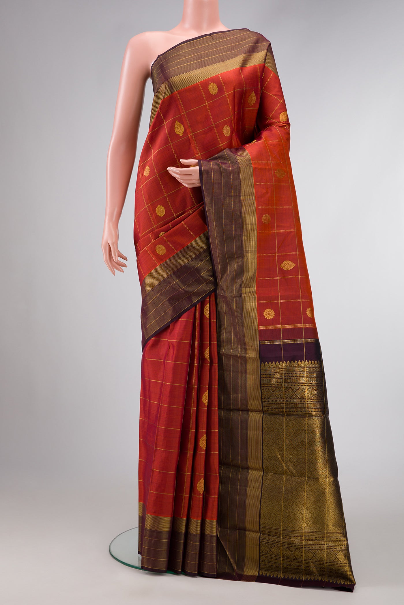 Brick Orange Dual Tone Kanjivaram Silk Saree with Checked design on the body and Zari Border.  displayed on a mannequin