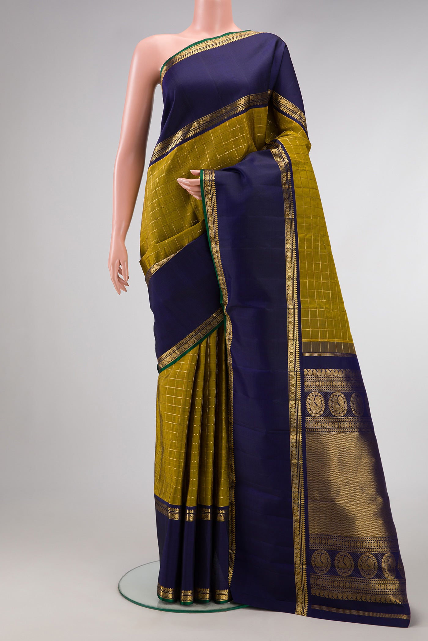 Mehandi Green Dual Tone Kanjivaram Silk Saree with Checked design on the body and Zari Border.  displayed on a mannequin
