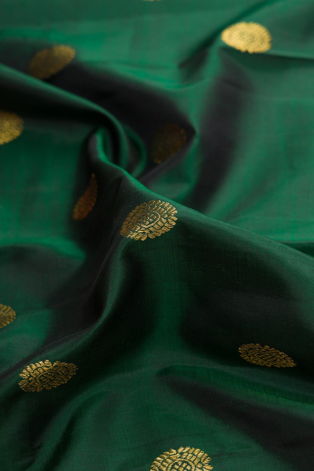 Close up of Bottle Green Dual Tone Kanchipuram Silk Saree with Zari Butta on the body and Zari Border.  displaying folds