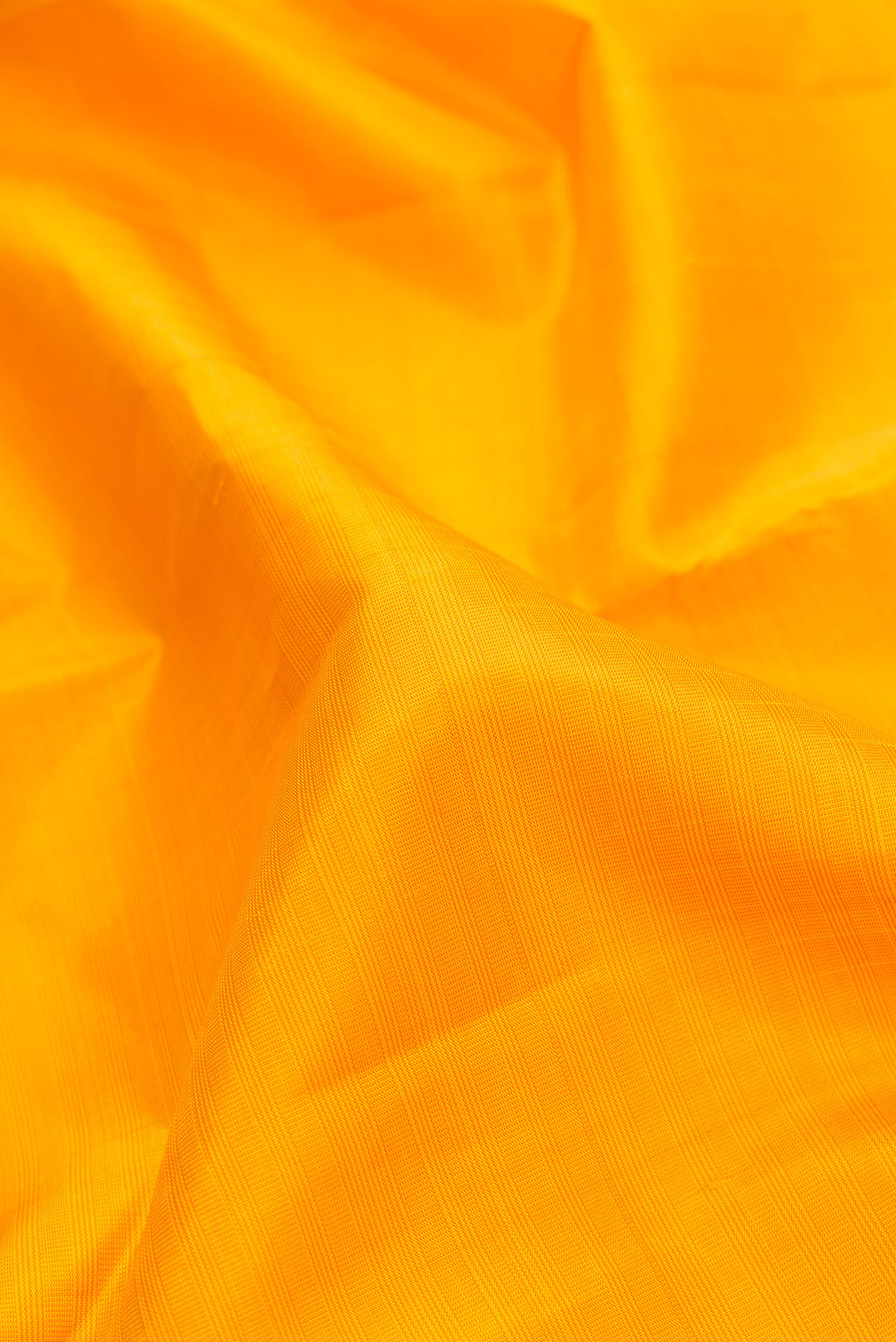 Close up of Yellow Dual Tone Kanjivaram Silk Saree with Checked design on the body and Zari Border.  displaying folds
