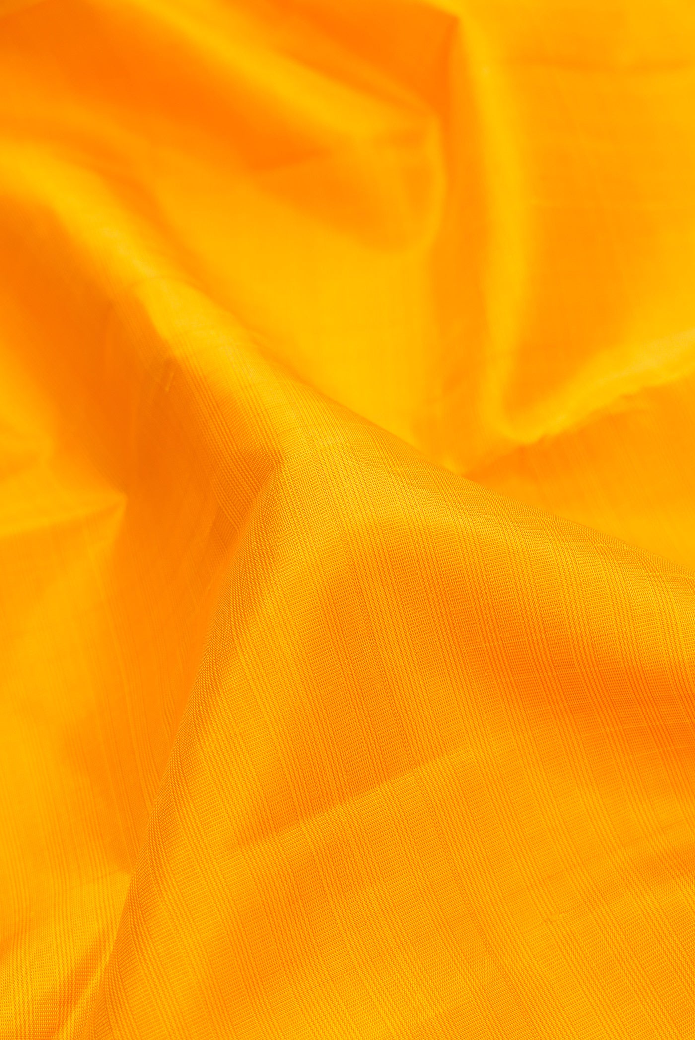 Close up of Yellow Dual Tone Kanjivaram Silk Saree with Checked design on the body and Zari Border.  displaying folds
