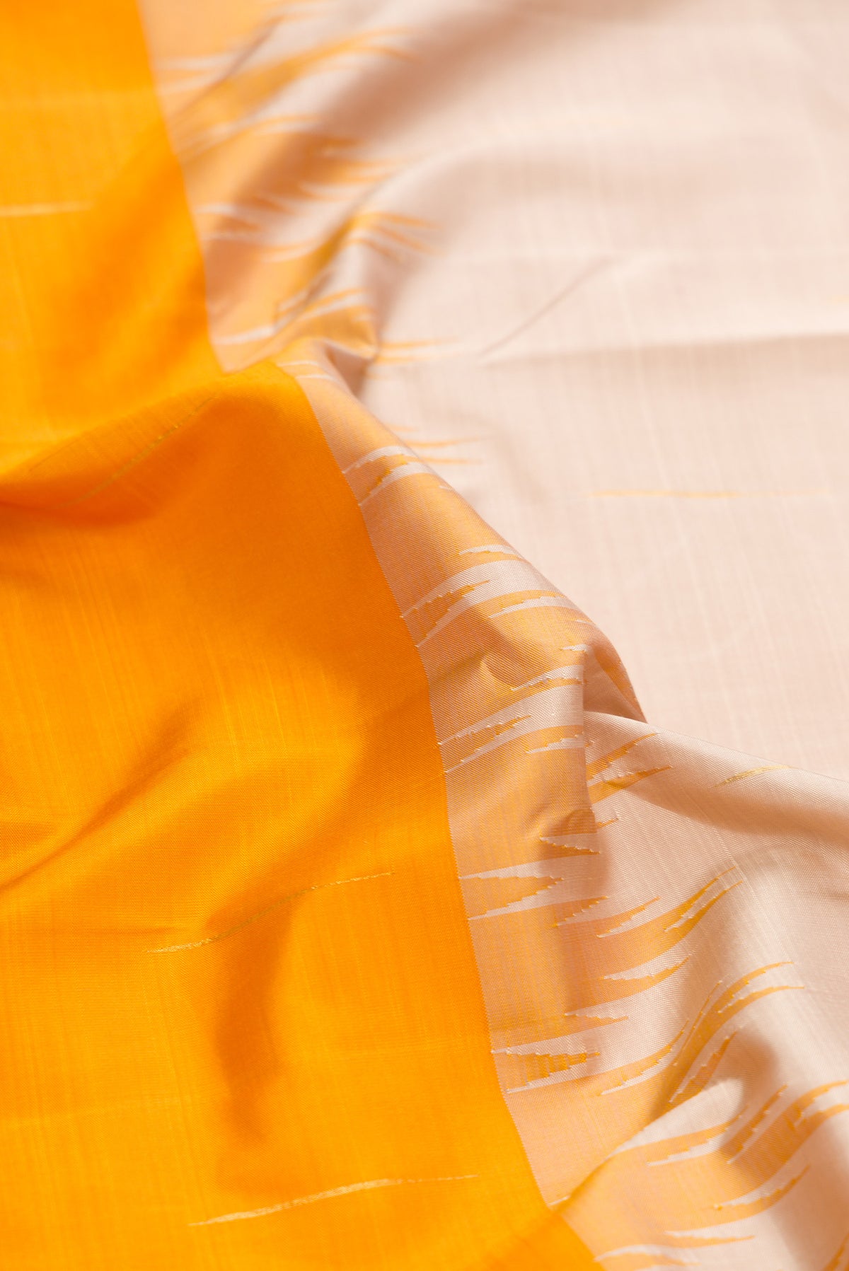 Close up of Beige and Mustard Color Kanjivaram Silk Saree with Half And Half on the body and Thin Zari Line.  displaying folds