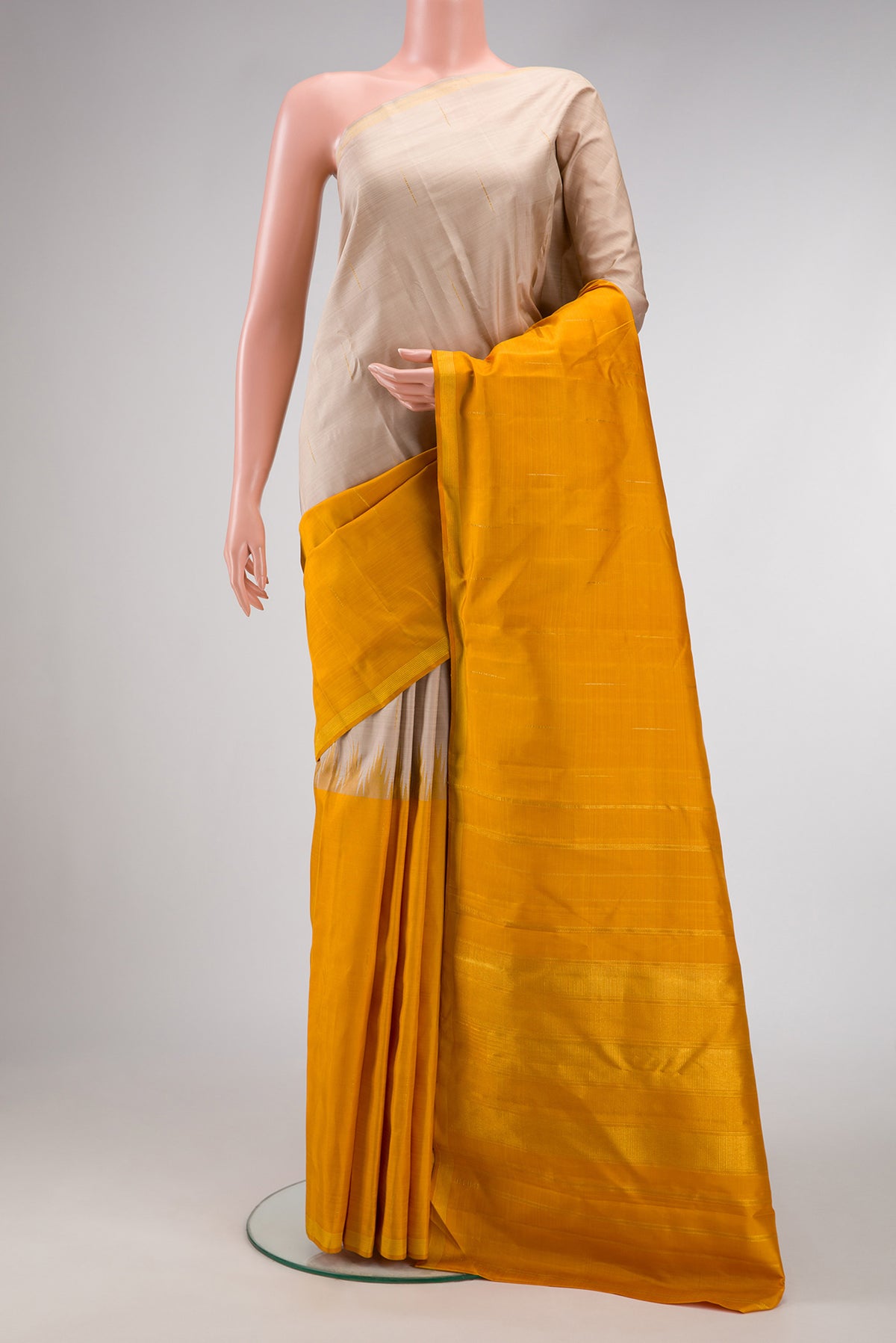 Beige and Mustard Color Kanjivaram Silk Saree with Half And Half on the body and Thin Zari Line.  displayed on a mannequin