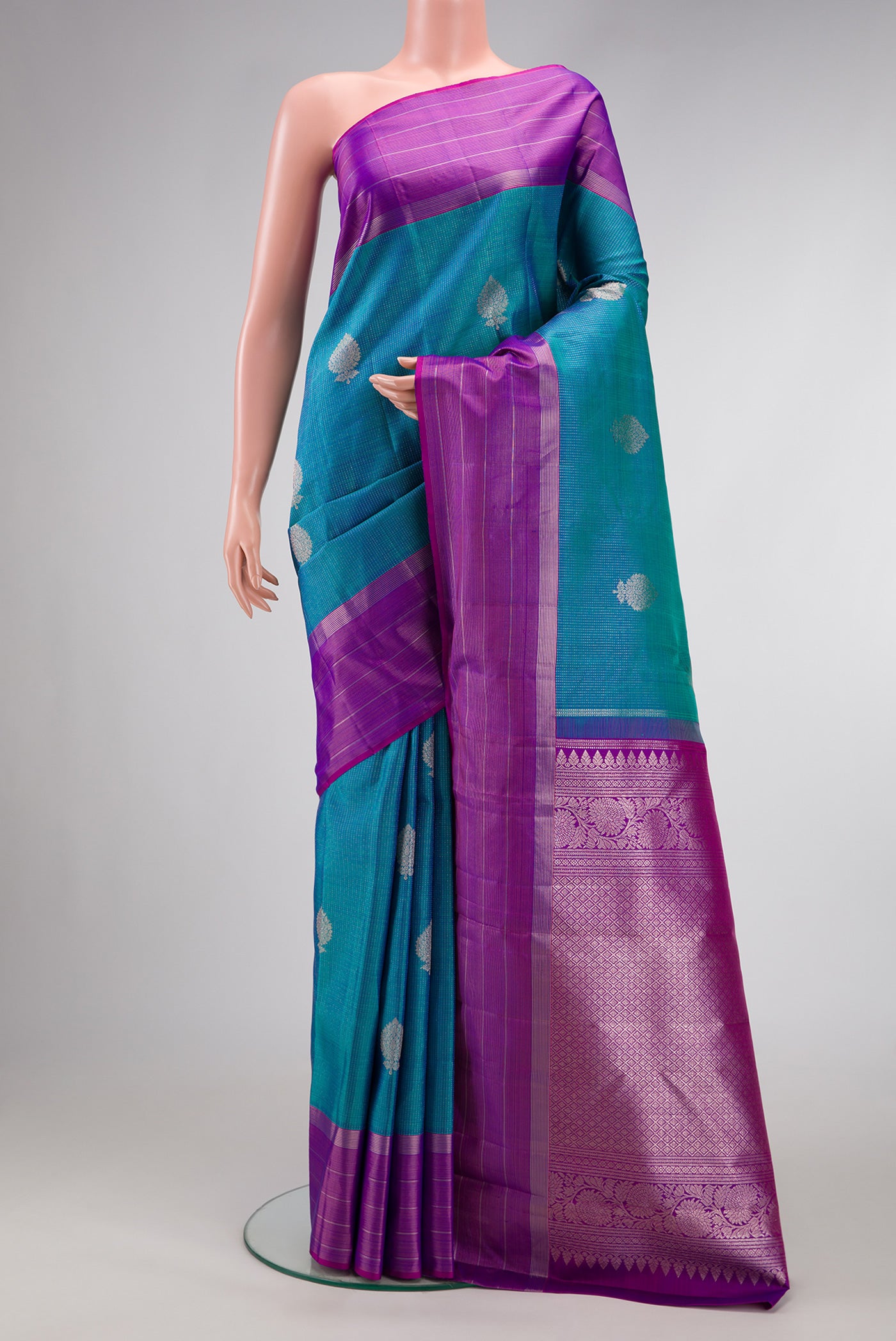 Peacock Blue Dual Tone Kanjivaram Silk Saree with Zari Butta on the body and Zari Border.  displayed on a mannequin