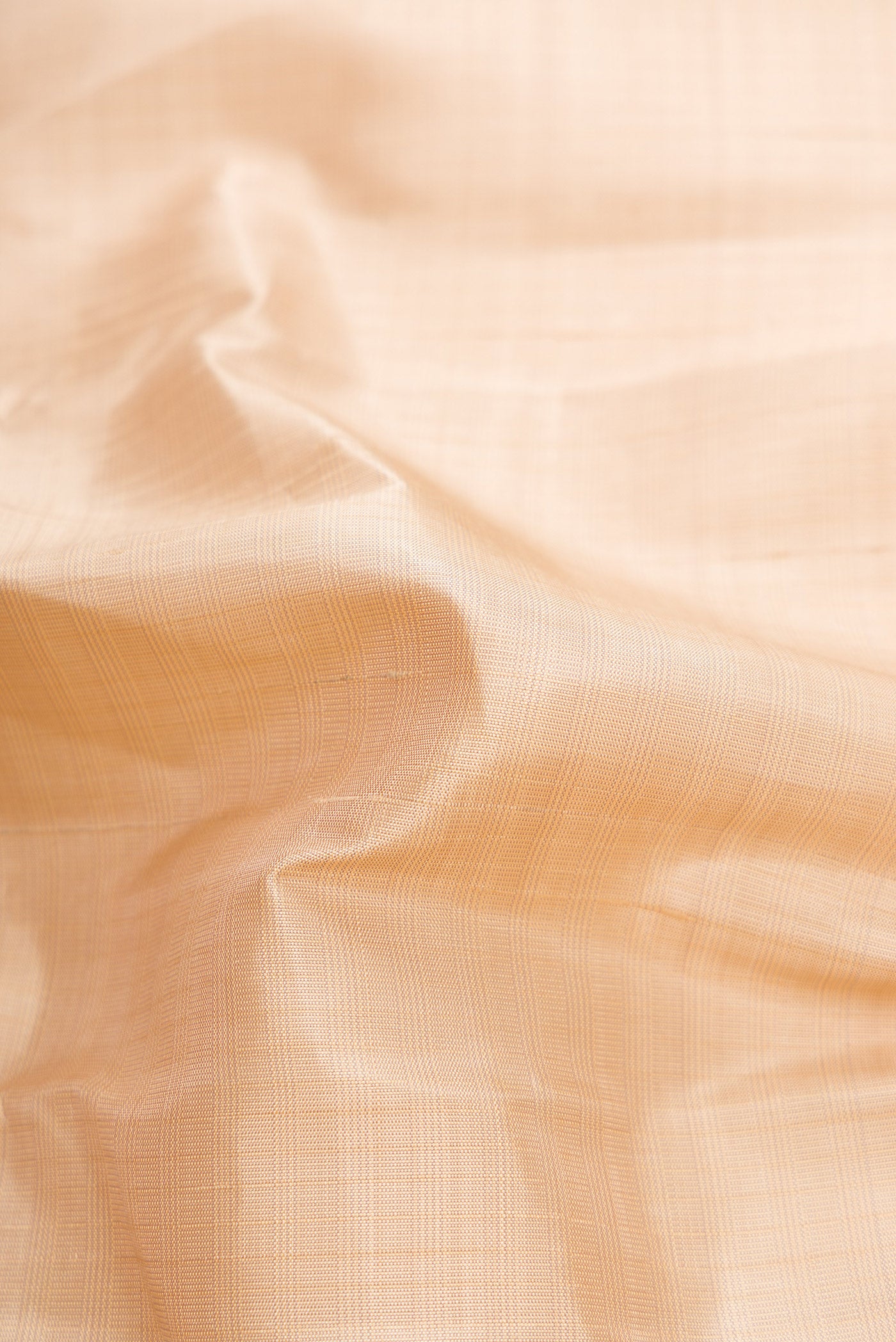 Close up of Beige Dual Tone Kanjivaram Silk Saree with Checked design on the body and Zari Border.  displaying folds