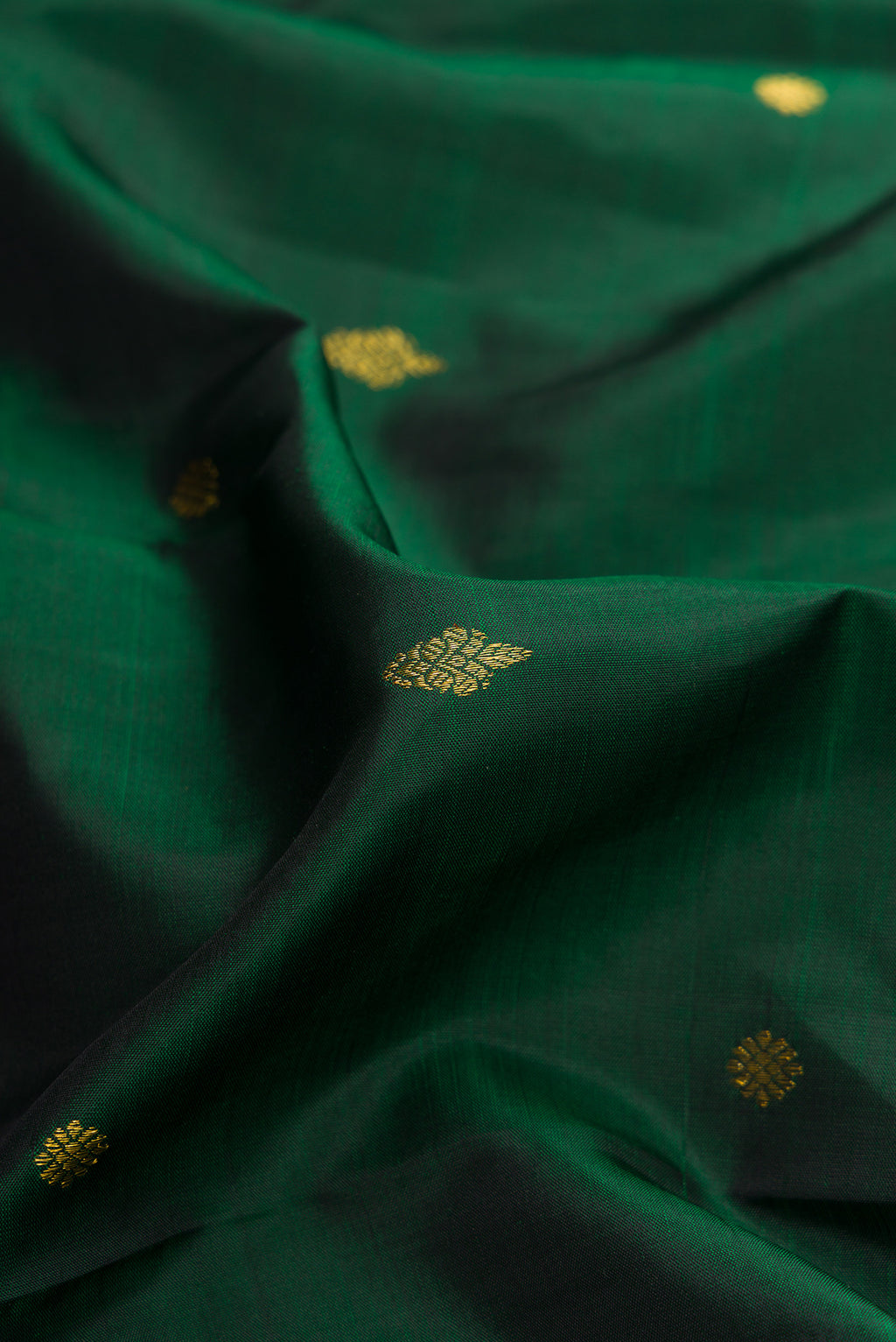 Close up of Green Dual Tone Kanjivaram Silk Saree with Zari Butta on the body and Fancy Border.  displaying folds