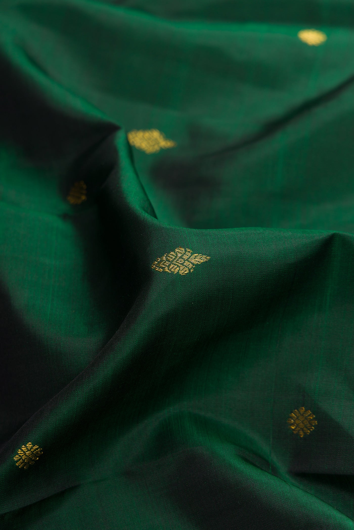 Close up of Green Dual Tone Kanjivaram Silk Saree with Zari Butta on the body and Fancy Border.  displaying folds