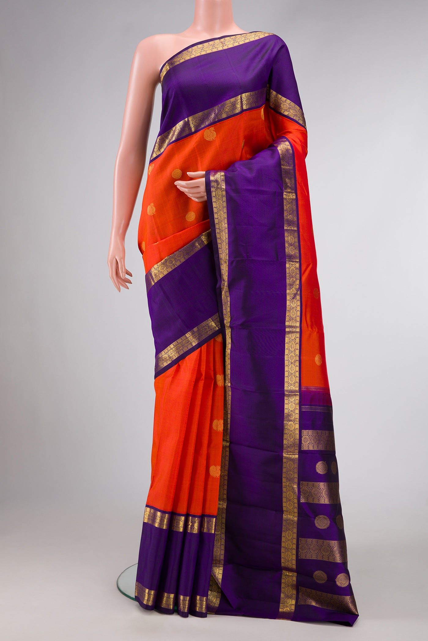 Orange Dual Tone Kanjivaram Silk Saree with Zari Butta on the body and Zari Border.  displayed on a mannequin