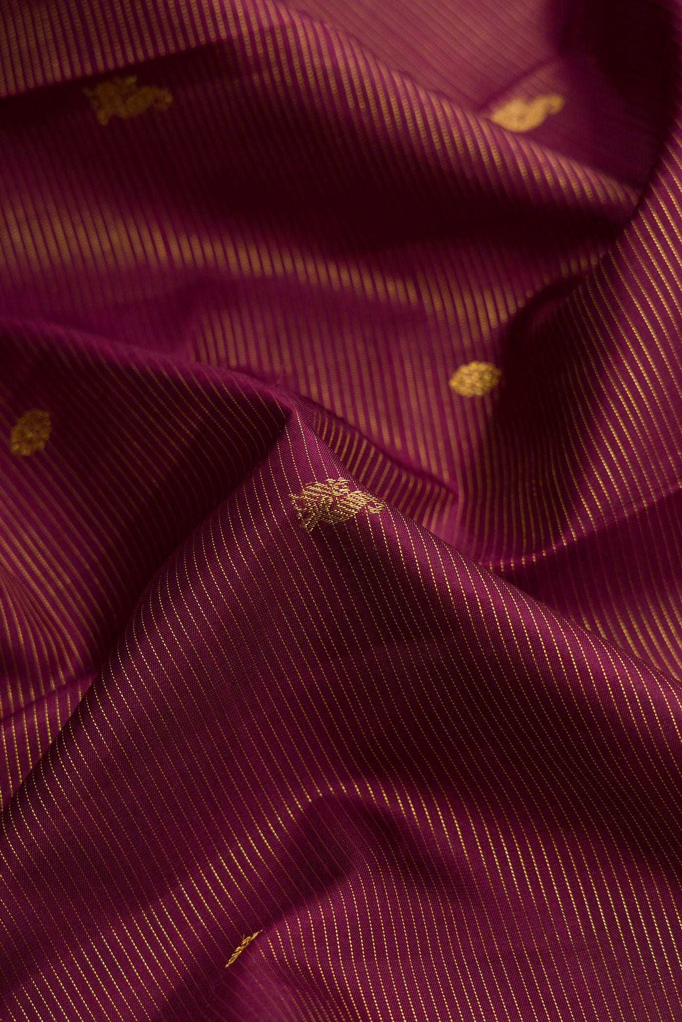 Close up of Burgundy Dual Tone Kanjivaram Silk Saree with Stripes on the body and Zari Border.  displaying folds