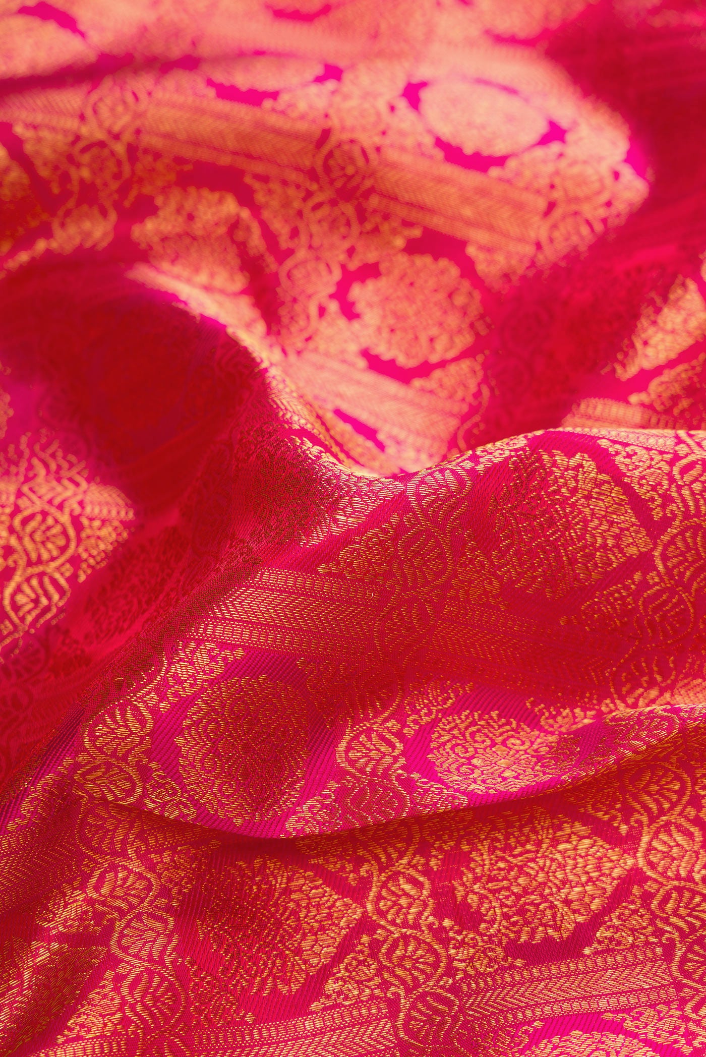 Close up of Dark Pink Dual Tone Kanchipuram Silk Saree with Zari Brocade on the body and Zari Border.  displaying folds
