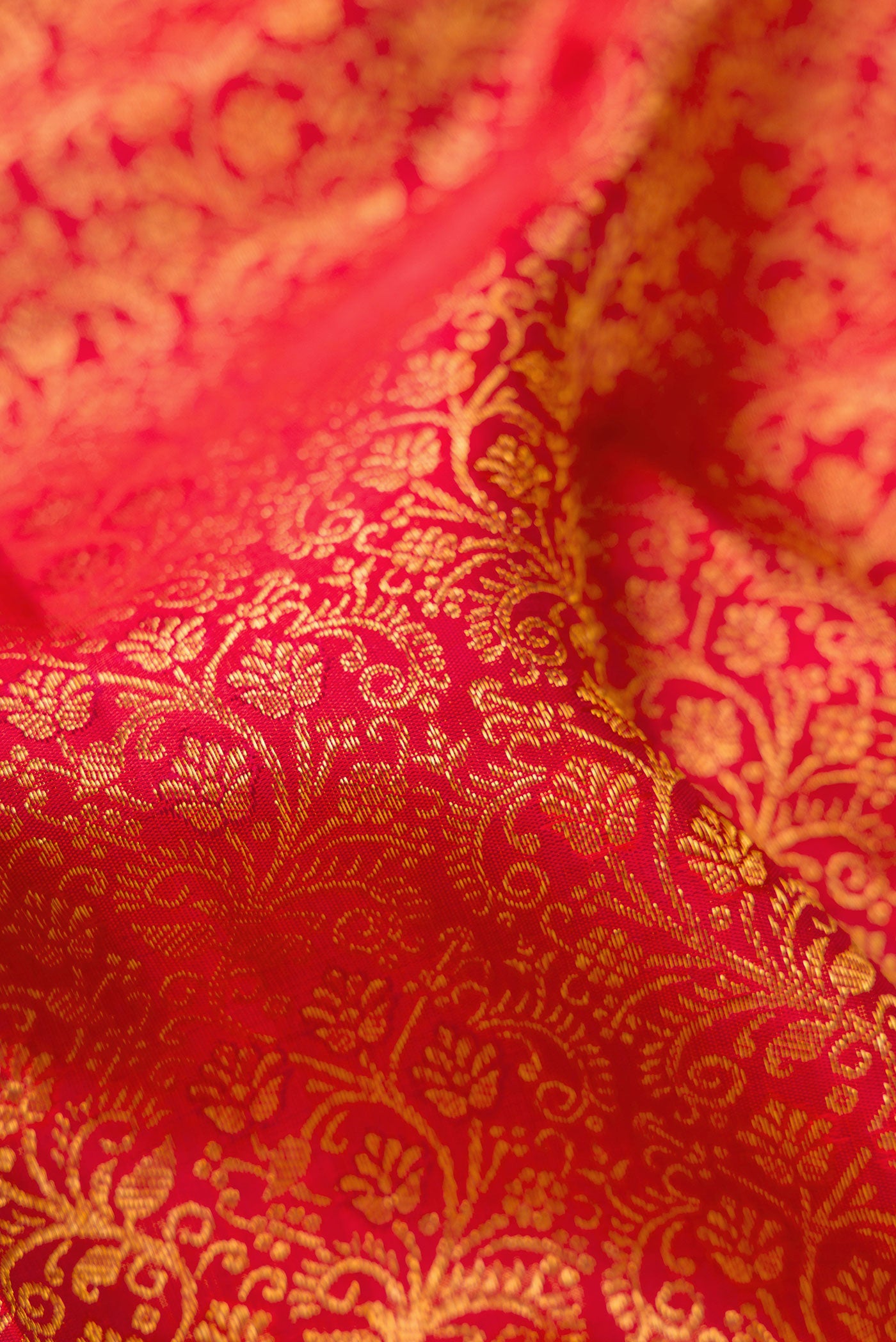 Close up of Red Dual Tone Kanchipuram Silk Saree with Zari Brocade on the body and Zari Border.  displaying folds