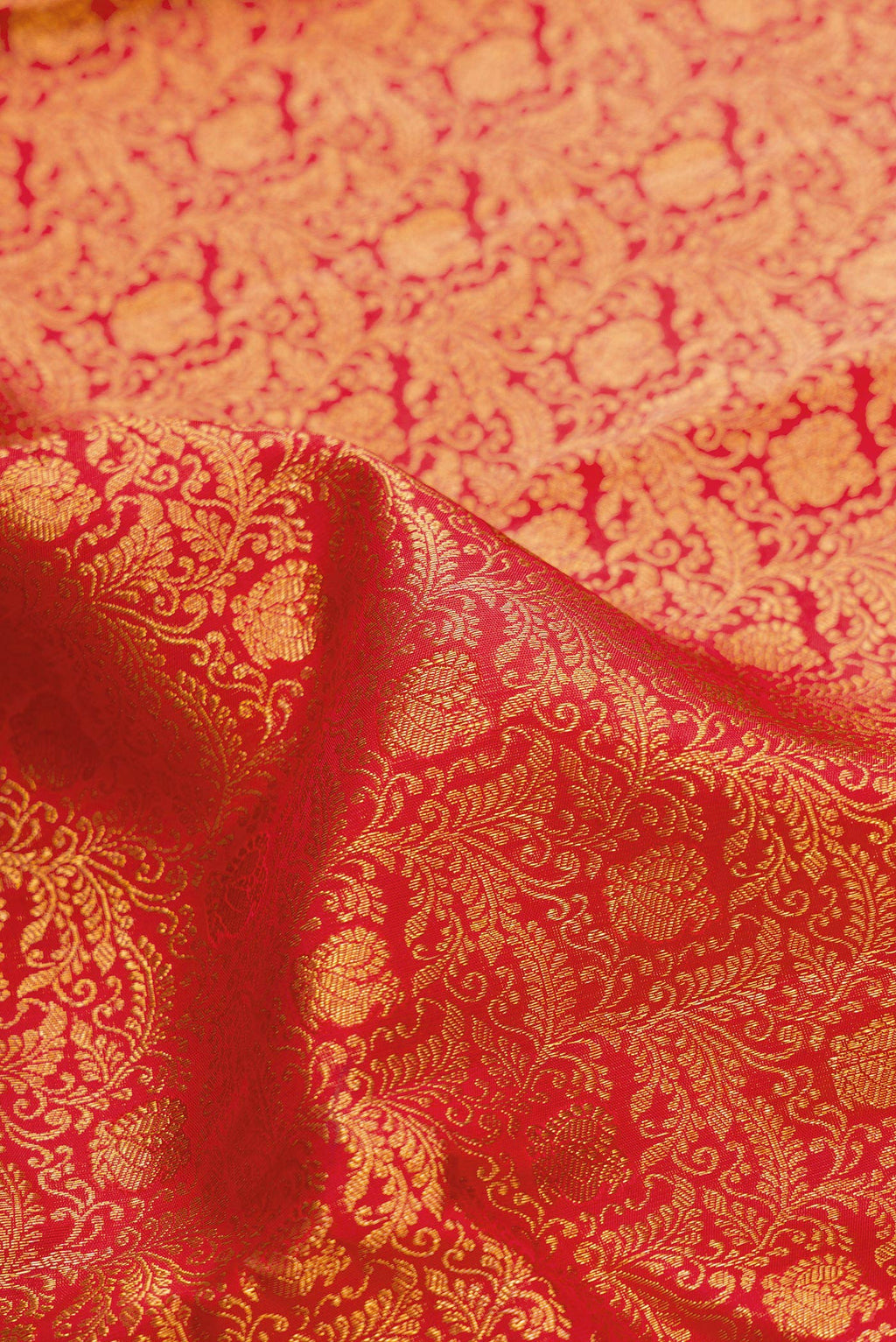 Close up of Red Dual Tone Kanchipuram Silk Saree with Zari Brocade on the body and Zari Border.  displaying folds