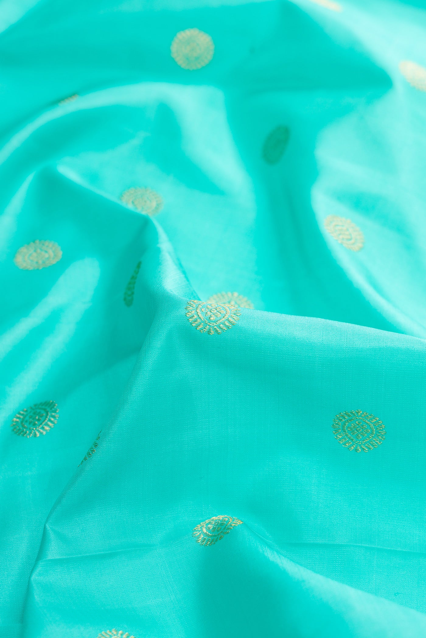 Close up of Sky Blue Dual Tone Kanchipuram Silk Saree with Zari Butta on the body and Zari Border.  displaying folds