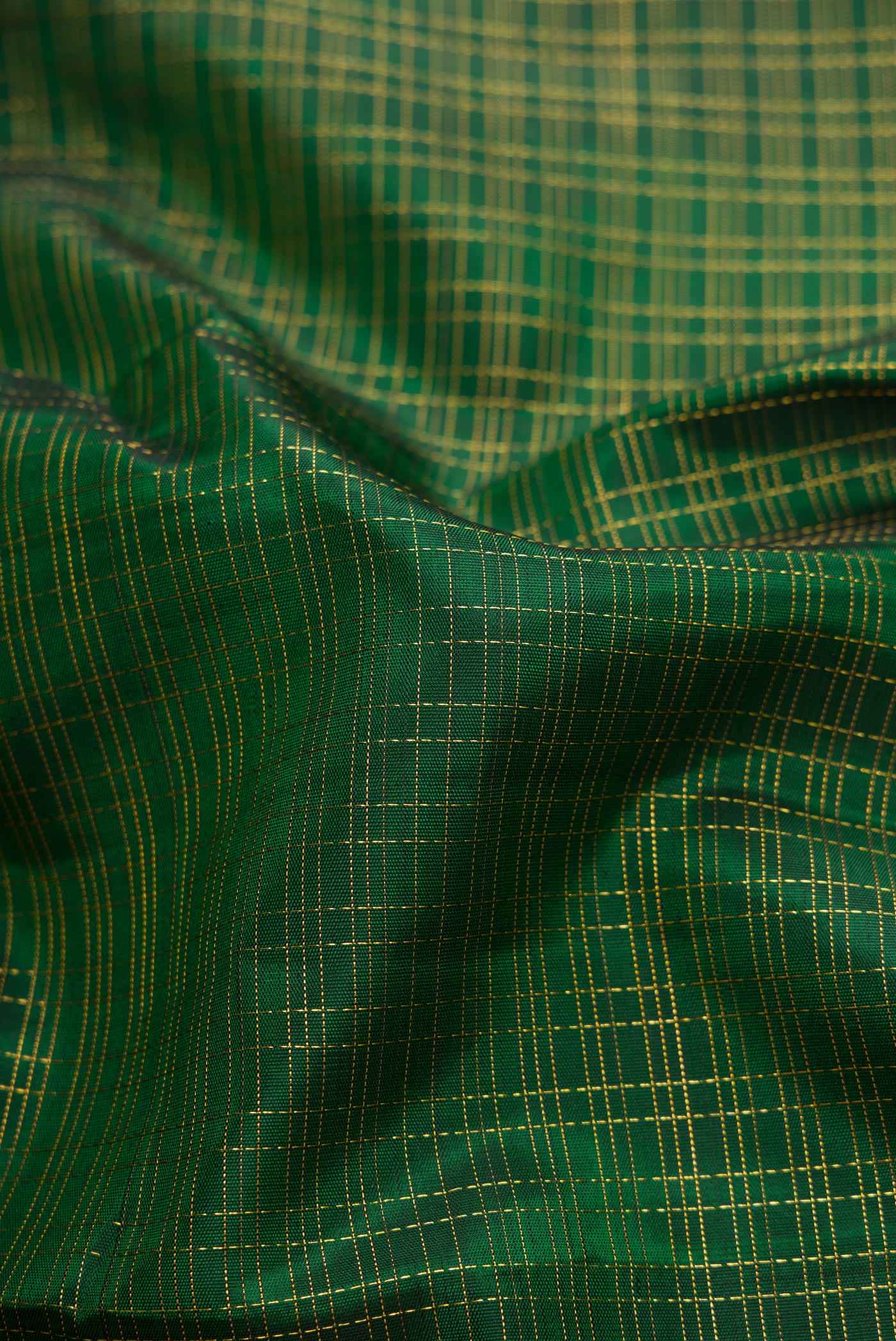 Close up of Bottle Green Dual Tone Kanchipuram Silk Saree with Checked design on the body and Zari Border.  displaying folds
