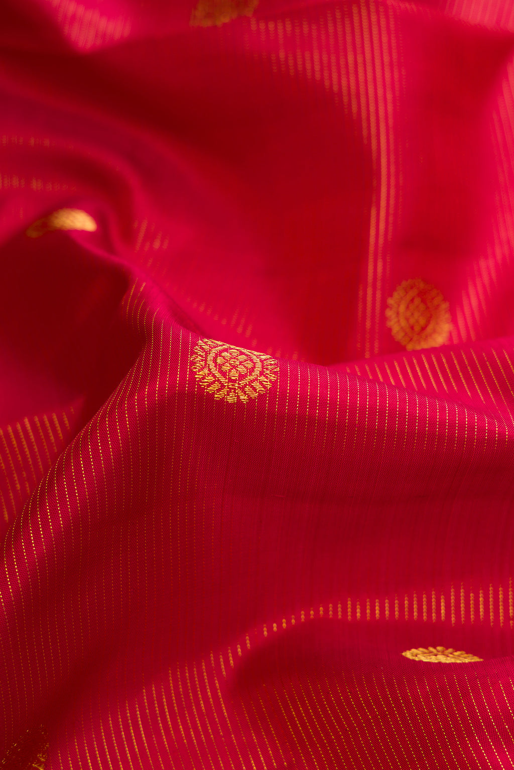 Close up of Maroon Dual Tone Kanchipuram Silk Saree with Zari Butta on the body and Zari Border.  displaying folds