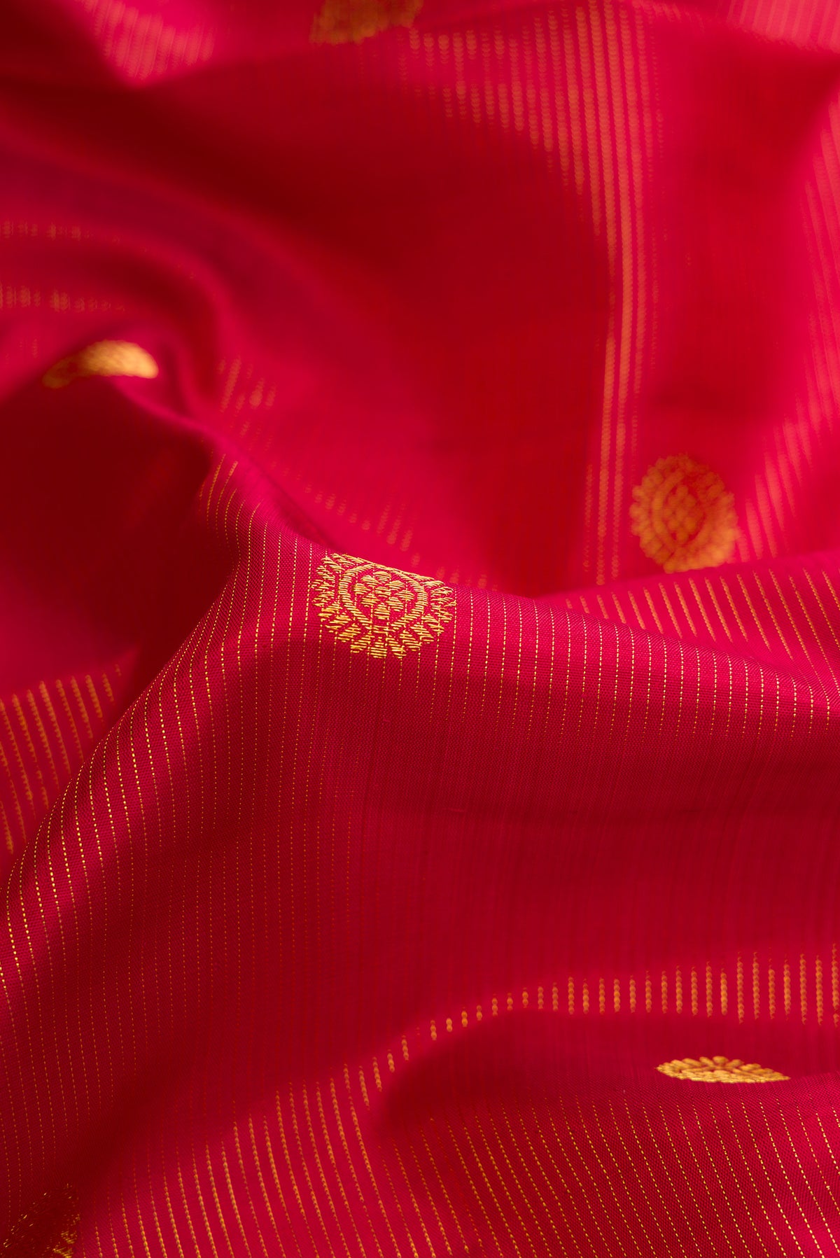 Close up of Maroon Dual Tone Kanchipuram Silk Saree with Zari Butta on the body and Zari Border.  displaying folds