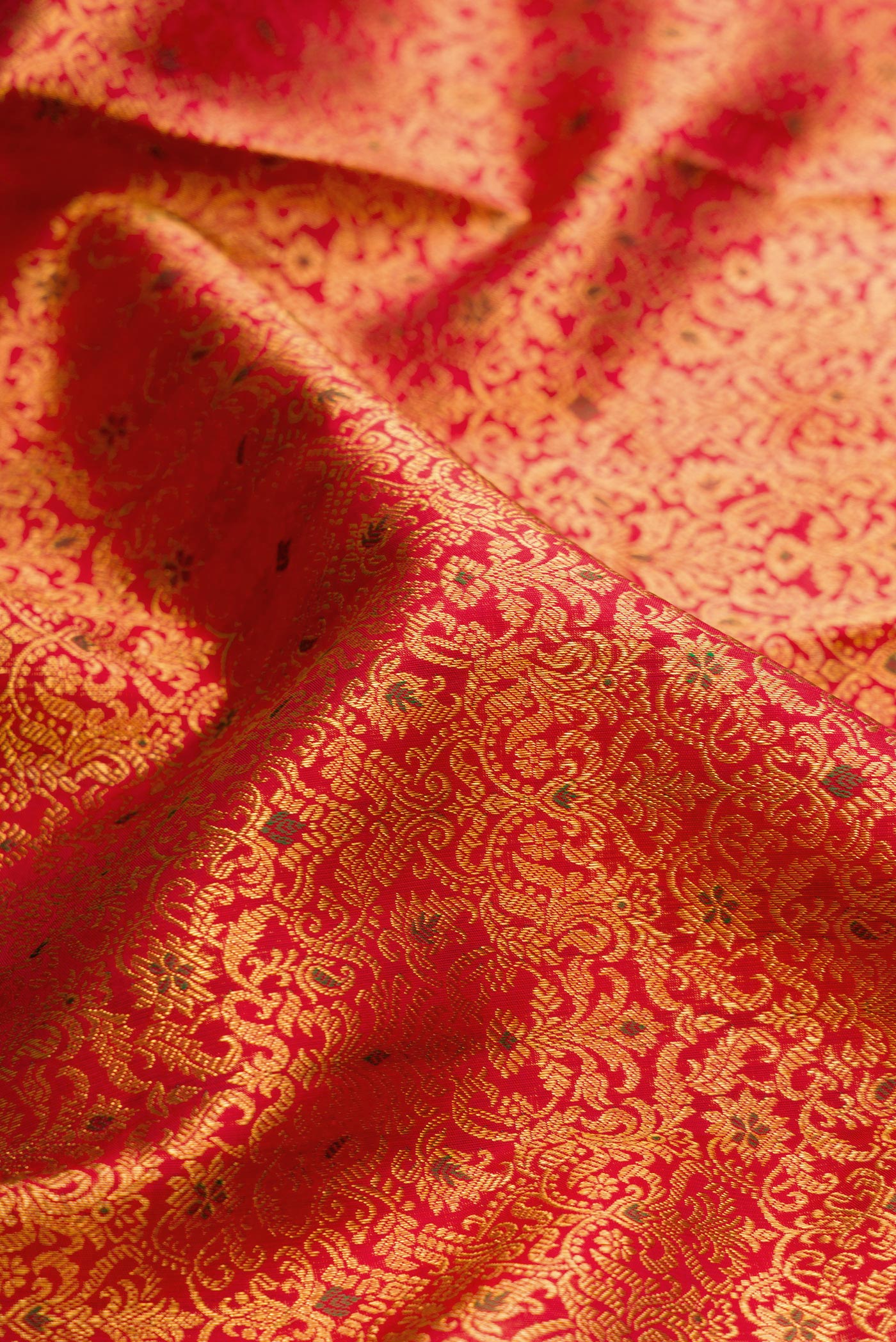 Close up of Red Dual Tone Kanchipuram Silk Saree with Zari Brocade on the body and Zari Border.  displaying folds