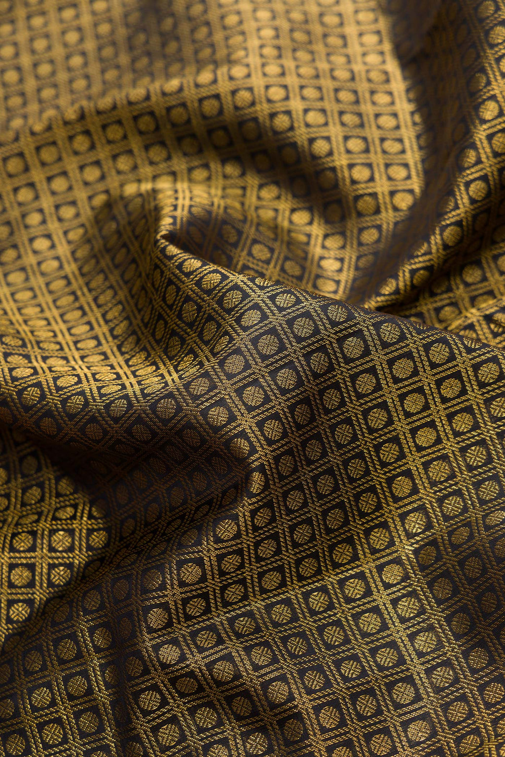 Close up of Black Dual Tone Kanchipuram Silk Saree with Zari Brocade on the body and Zari Border.  displaying folds