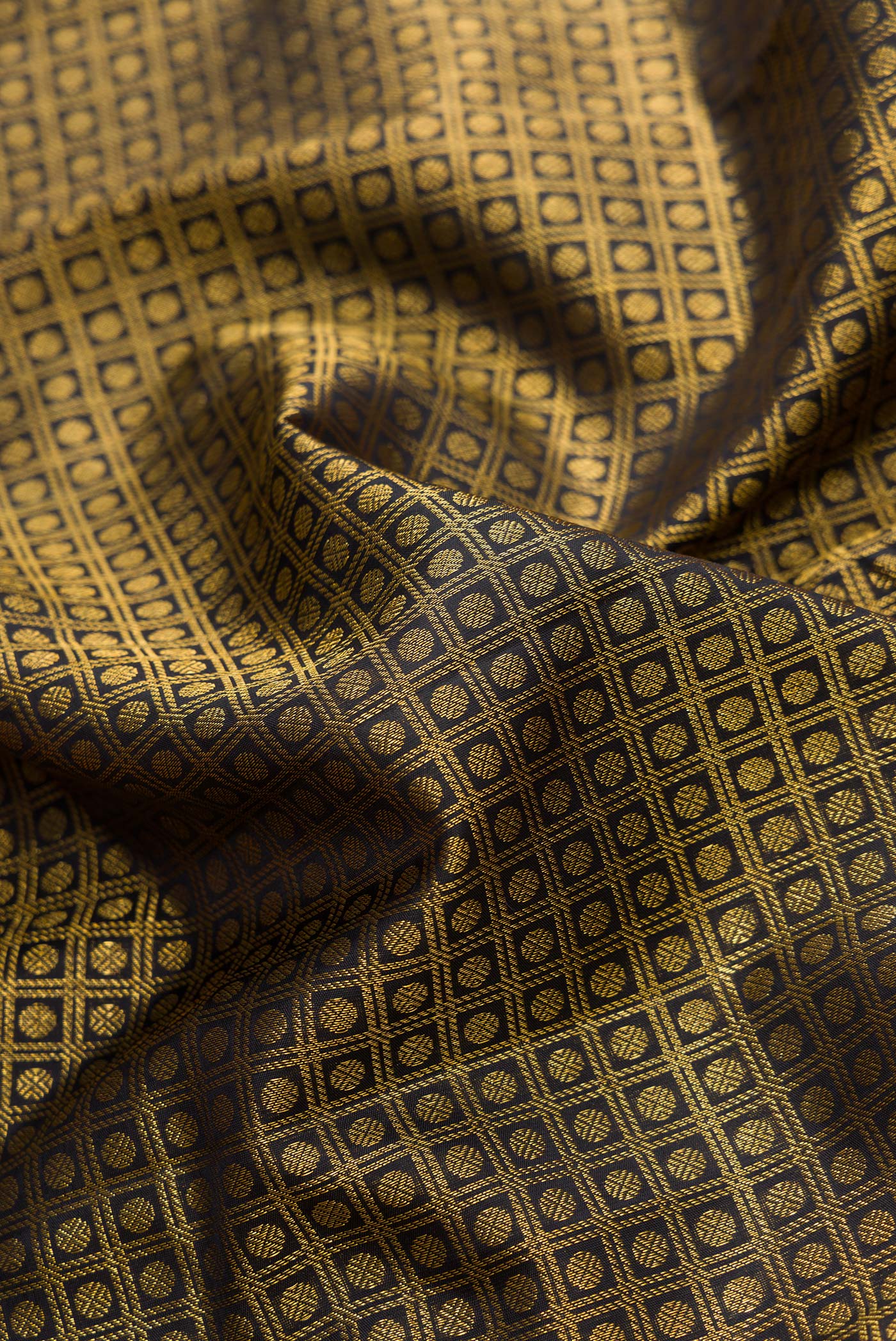 Close up of Black Dual Tone Kanchipuram Silk Saree with Zari Brocade on the body and Zari Border.  displaying folds