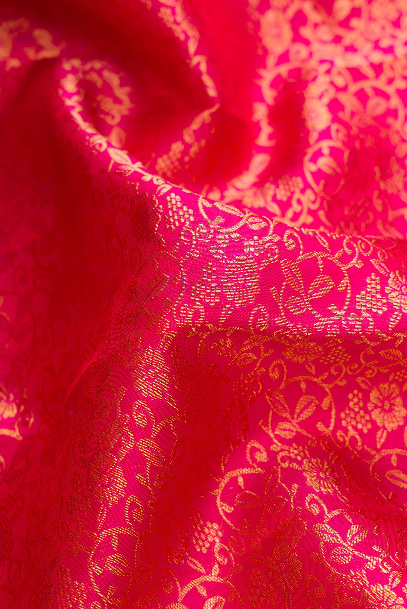 Close up of Dark Pink Dual Tone Kanchipuram Silk Saree with Zari Brocade on the body and Zari Border.  displaying folds