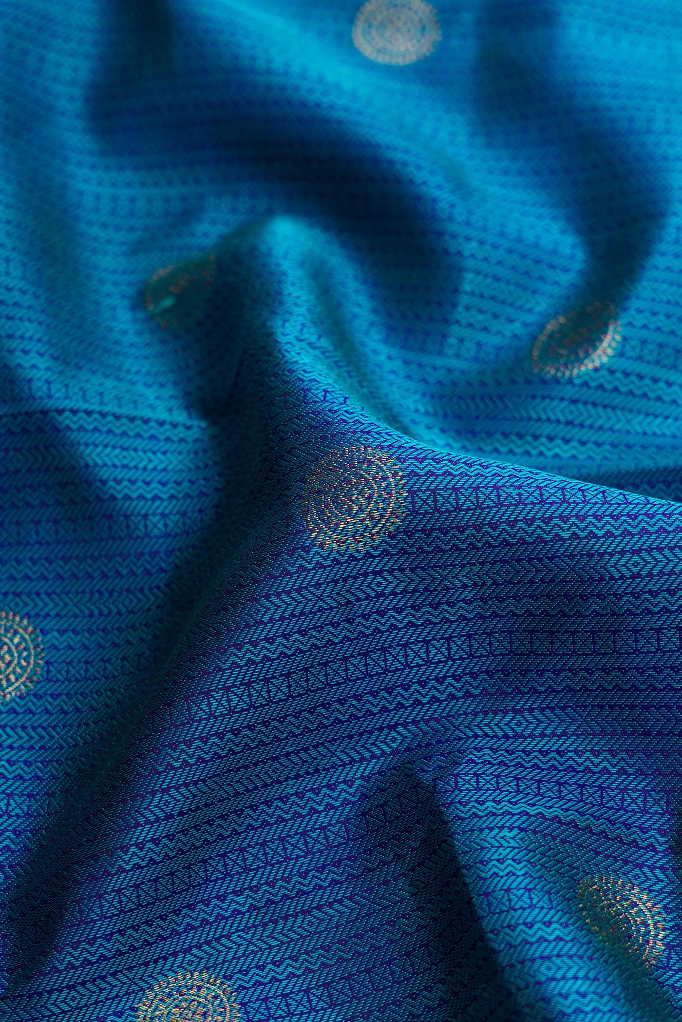 Close up of Peacock Blue Dual Tone Kanchipuram Silk Saree with Jacquard With Zari Butta on the body and Zari Border.  displaying folds