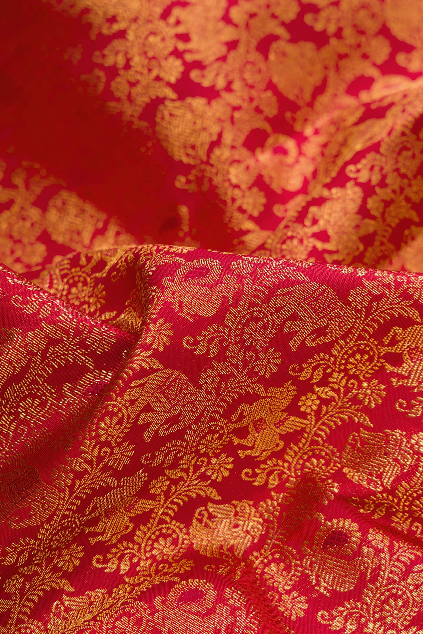 Close up of Red Dual Tone Kanchipuram Silk Saree with Zari Brocade on the body and Zari Border.  displaying folds