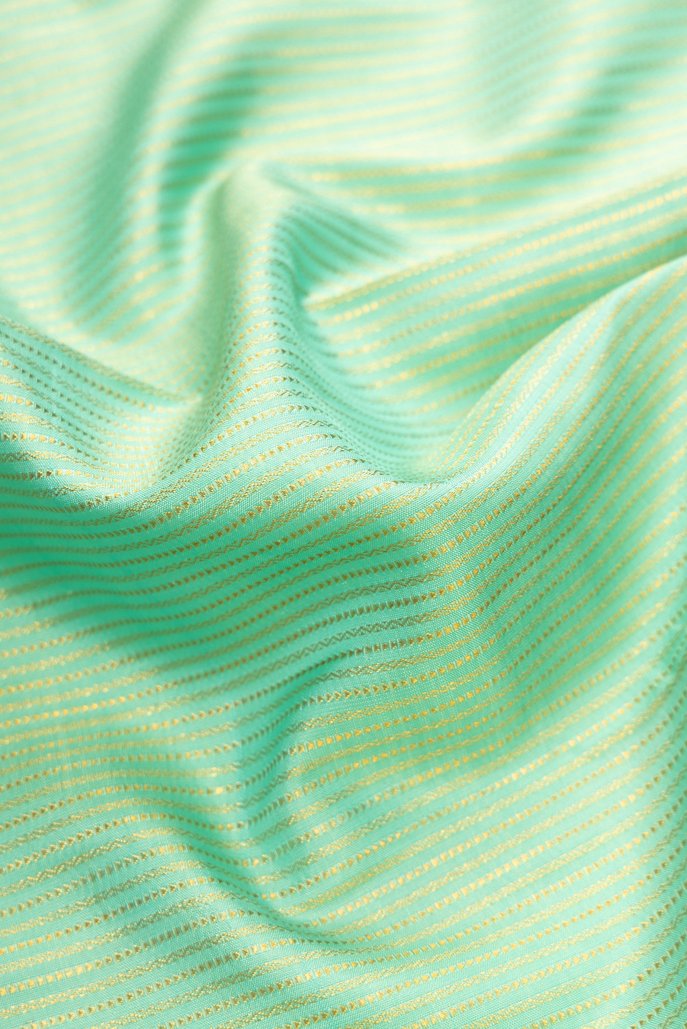 Close up of Pista Green Dual Tone Kanchipuram Silk Saree with Zari Brocade on the body and Zari Border.  displaying folds