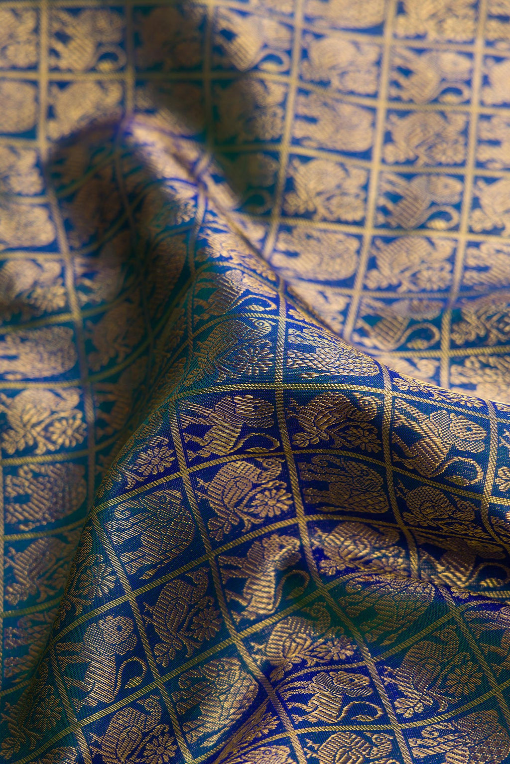 Close up of Peacock Blue Dual Tone Kanchipuram Silk Saree with Zari Brocade on the body and Zari Border.  displaying folds