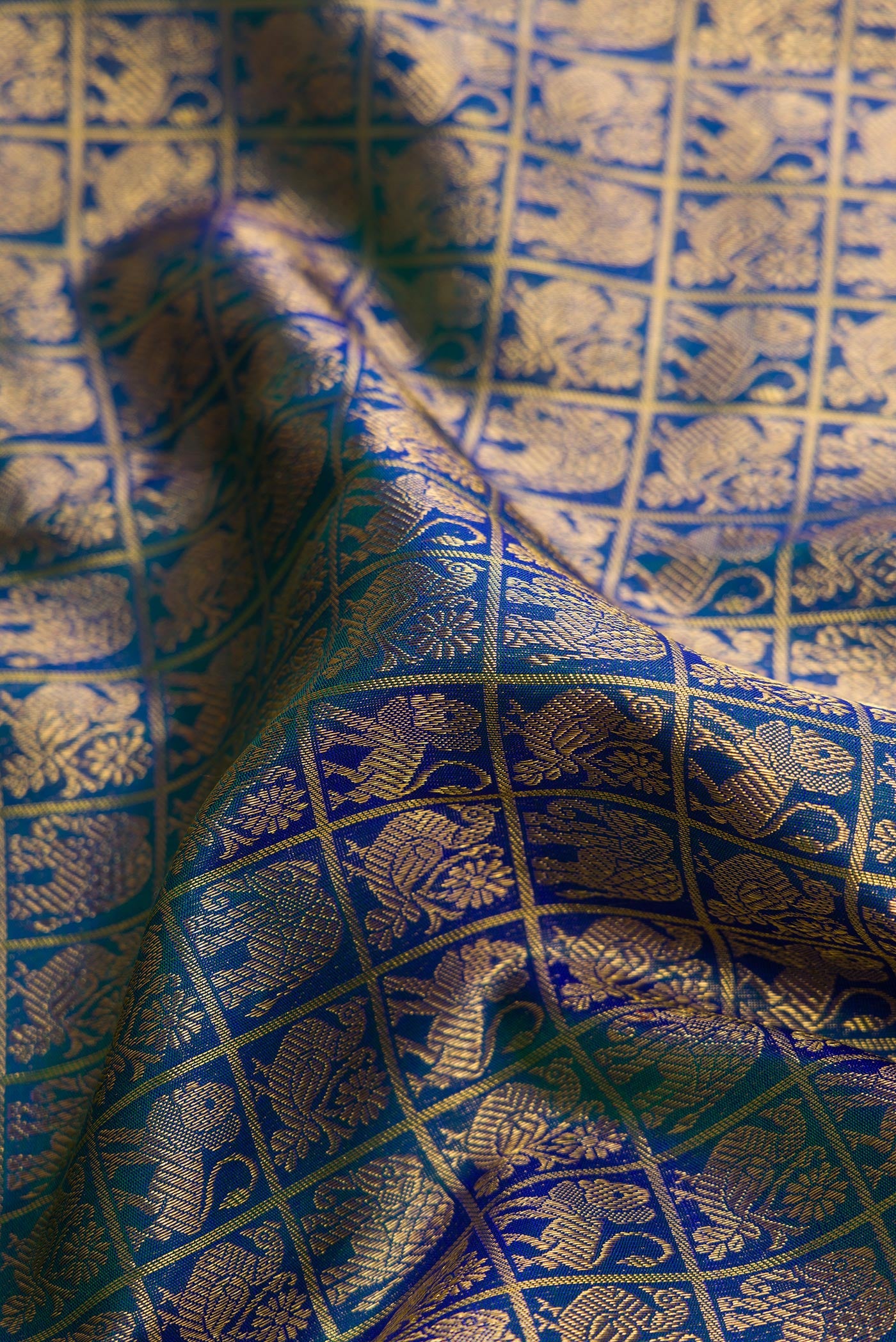 Close up of Peacock Blue Dual Tone Kanchipuram Silk Saree with Zari Brocade on the body and Zari Border.  displaying folds