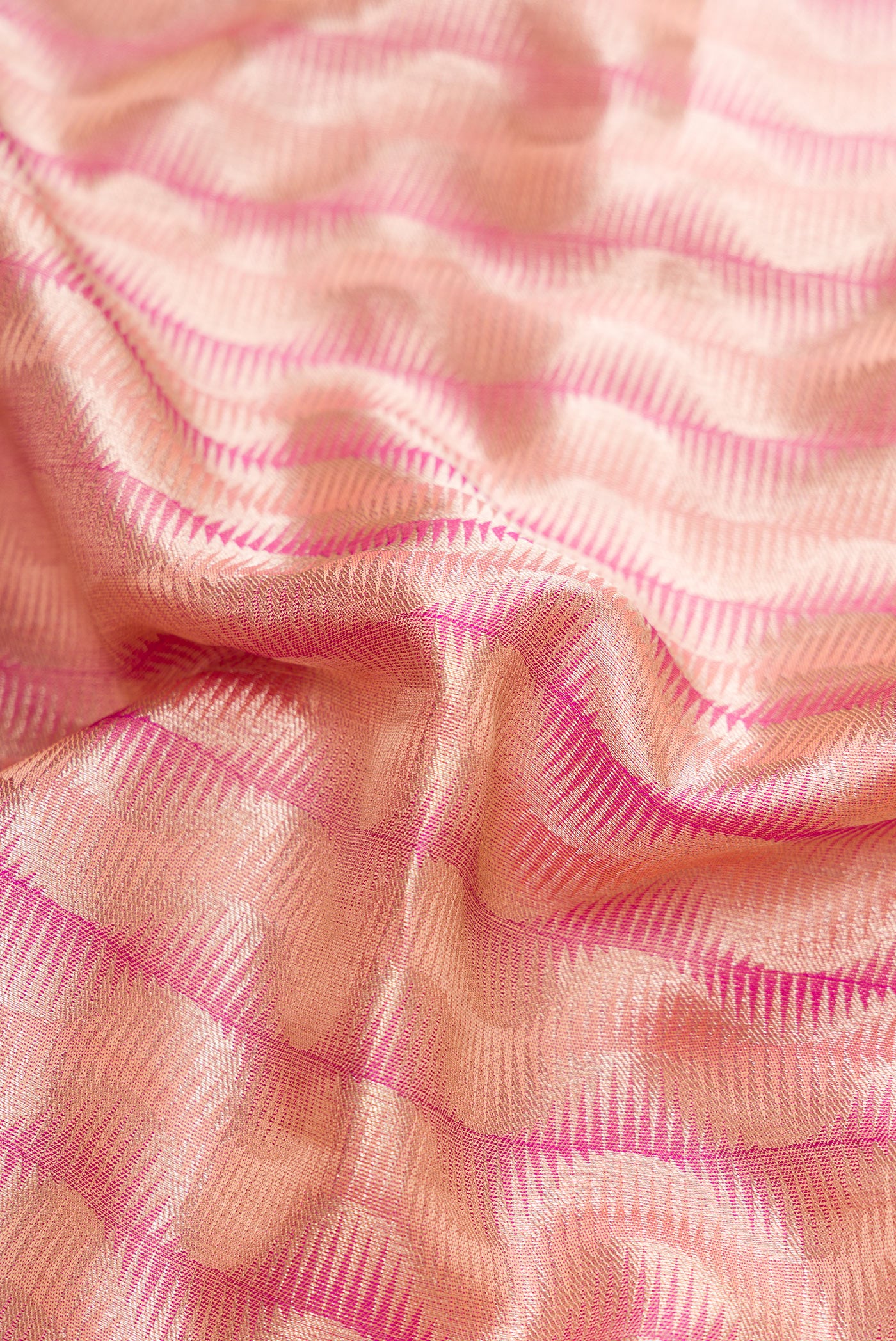 Close up of Golden Peach Dual Tone Kanjivaram Tissue Silk Saree with Zari Brocade on the body and Zari Border.  displaying folds
