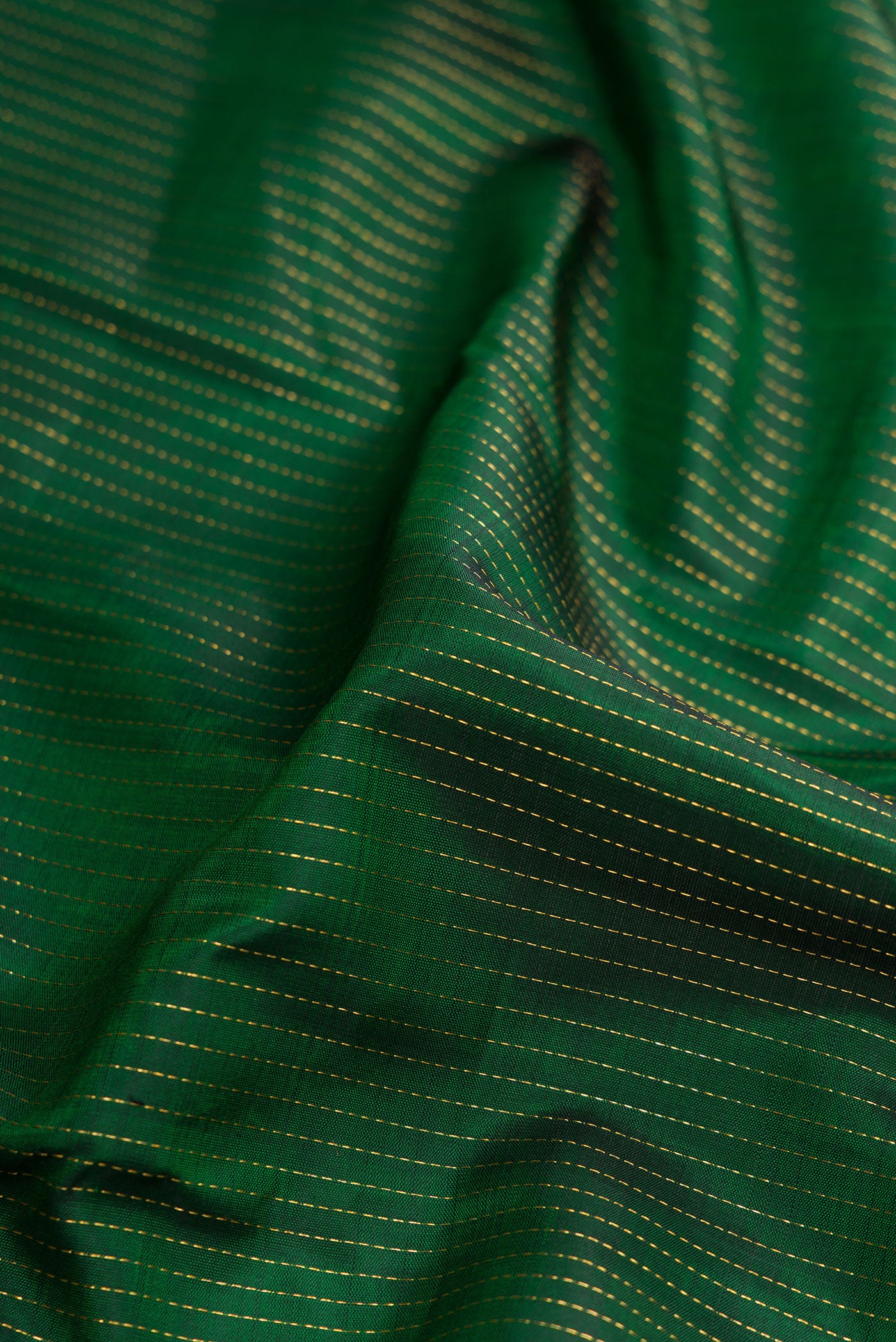 Close up of Green Dual Tone Kanjivaram Silk Saree with Stripes on the body and Zari Border.  displaying folds