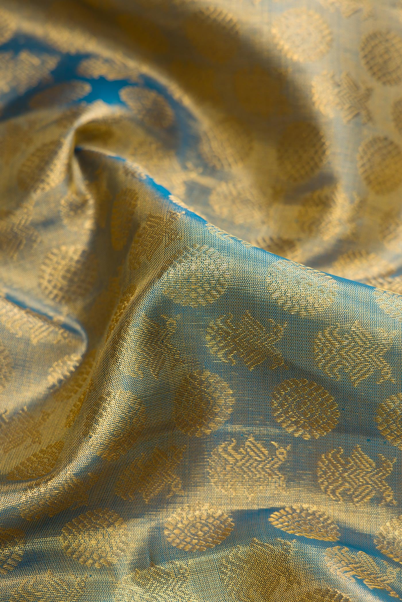 Close up of Maya Blue Dual Tone Kanchipuram Tissue Silk Saree with Zari Brocade on the body and Zari Border.  displaying folds