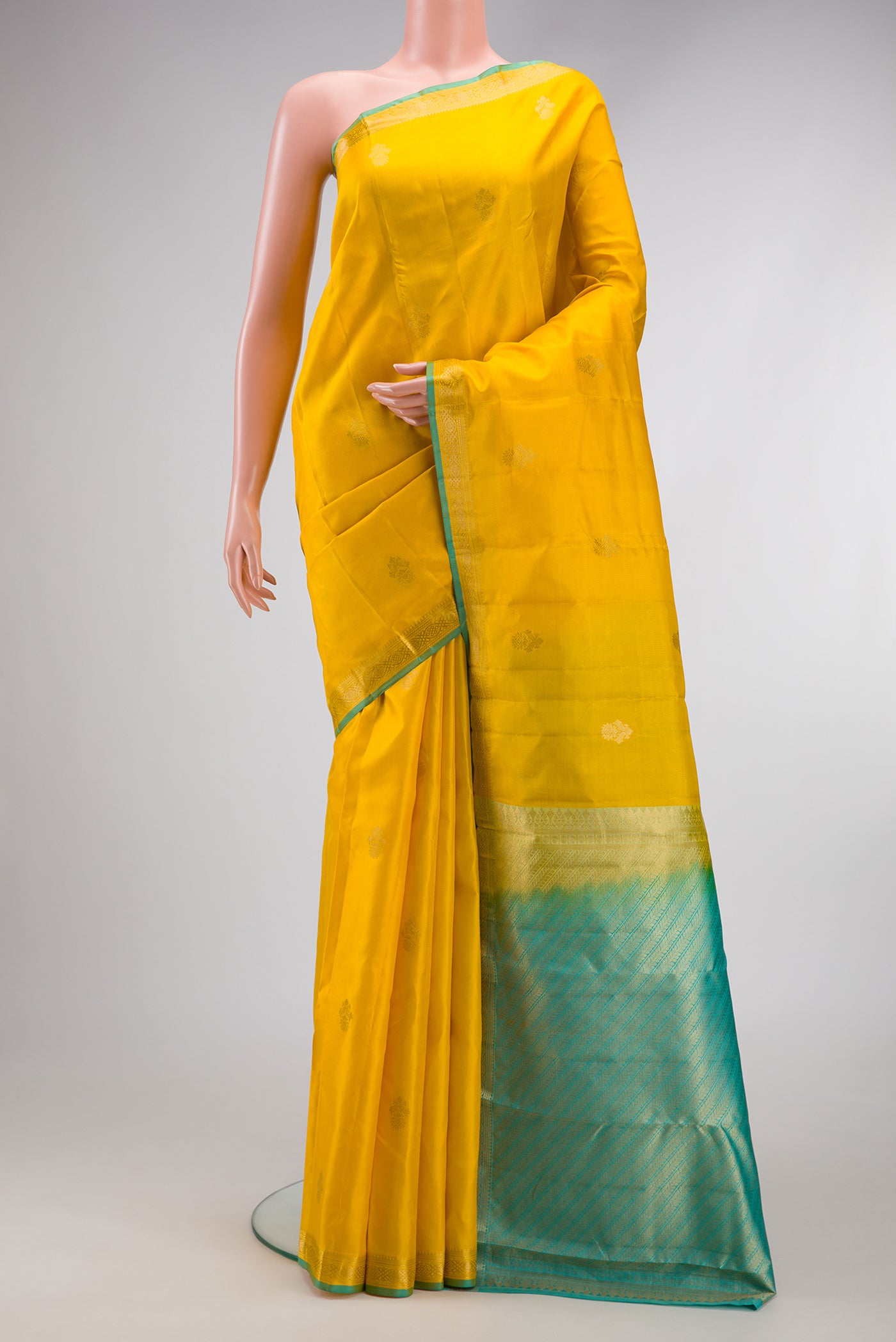 Yellow Dual Tone Kanchipuram Silk Saree with Zari Butta on the body and Zari Border.  displayed on a mannequin