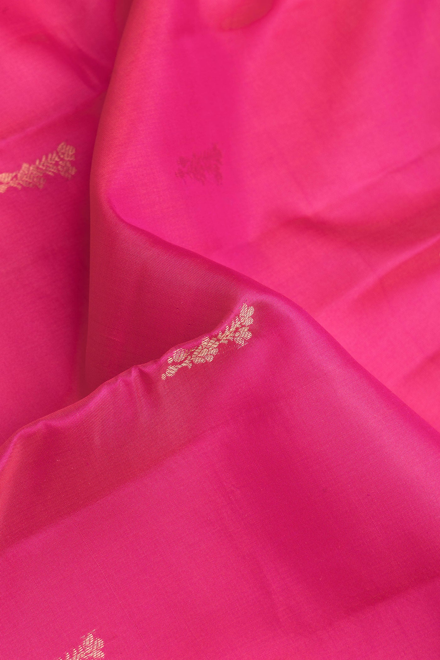 Close up of Pink Kanchipuram Silk Saree with Zari Butta on the body and Zari Border.  displaying folds