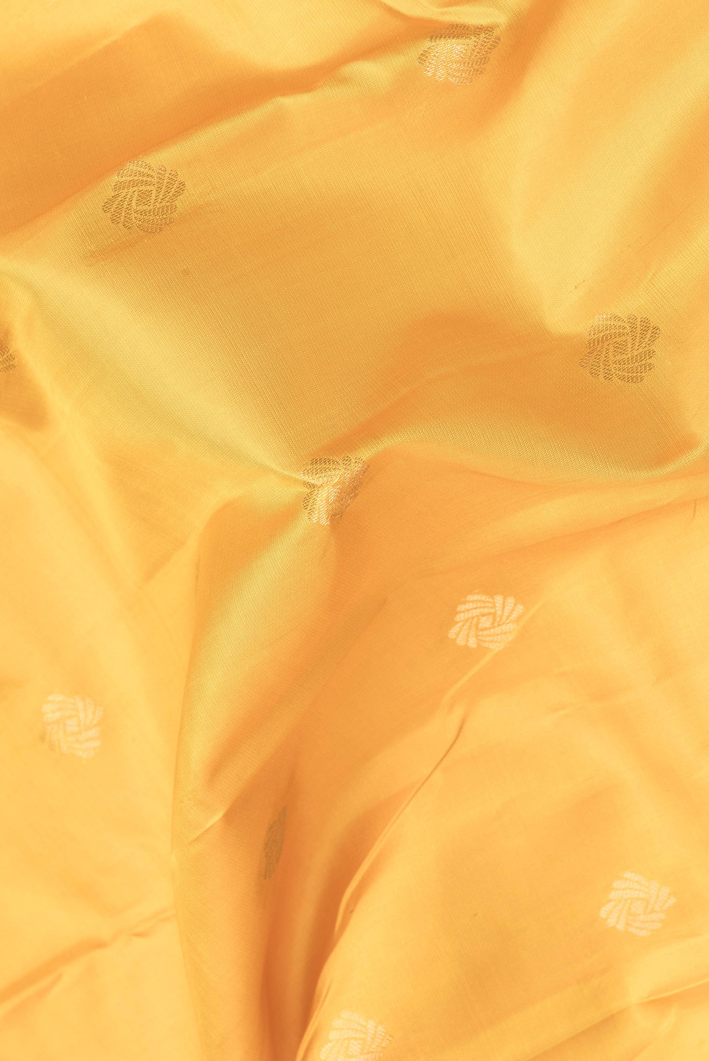 Close up of Mustard Dual Tone Kanchipuram Silk Saree with Zari Butta on the body and Zari Border.  displaying folds