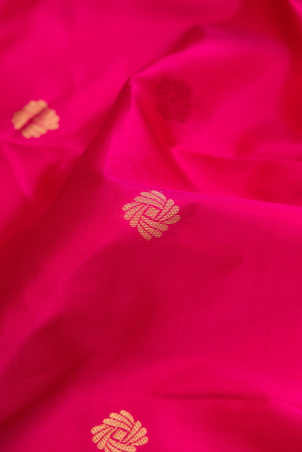 Close up of Pink Kanchipuram Silk Saree with Zari Butta on the body and Zari Border.  displaying folds