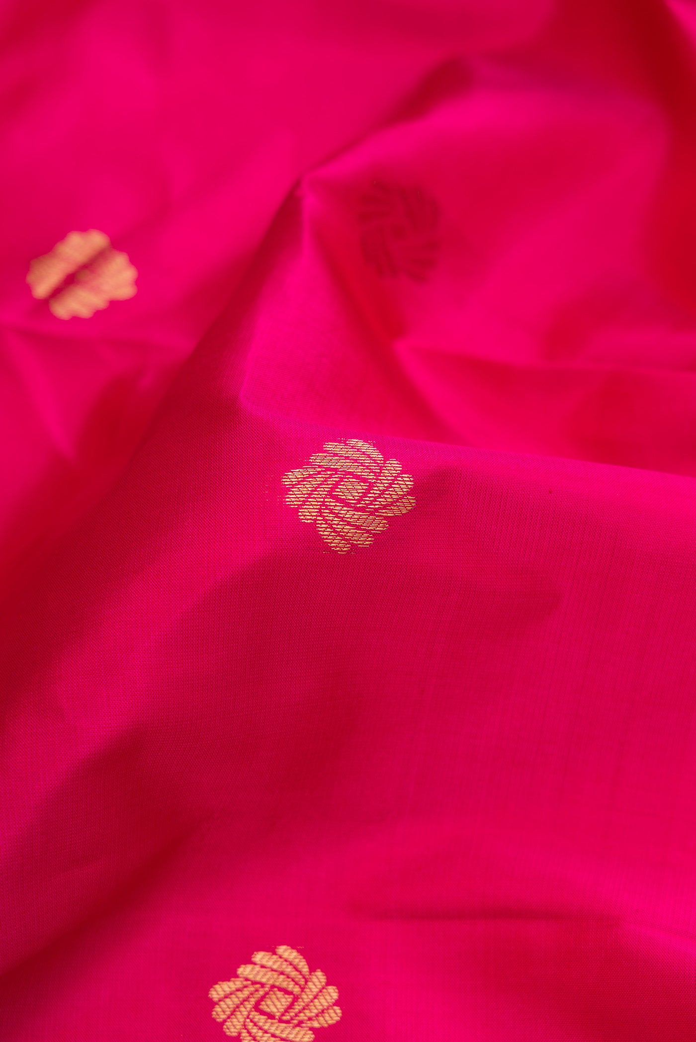 Close up of Pink Kanchipuram Silk Saree with Zari Butta on the body and Zari Border.  displaying folds