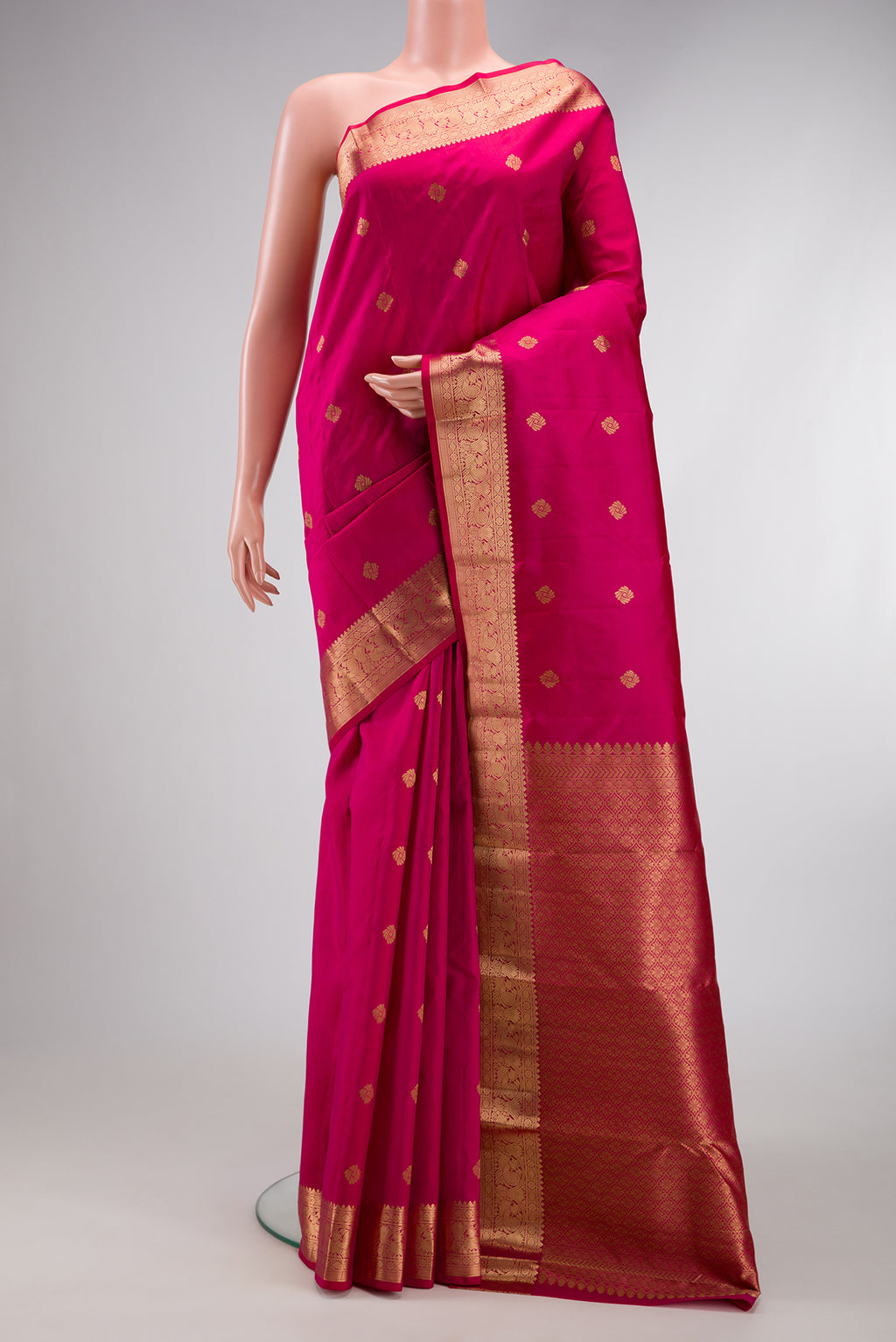 Pink Kanchipuram Silk Saree with Zari Butta on the body and Zari Border.  displayed on a mannequin