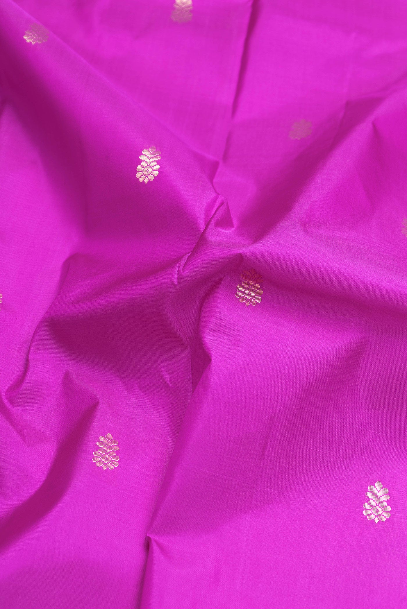 Close up of Magenta Dual Tone Kanchipuram Silk Saree with Zari Butta on the body and Zari Border.  displaying folds