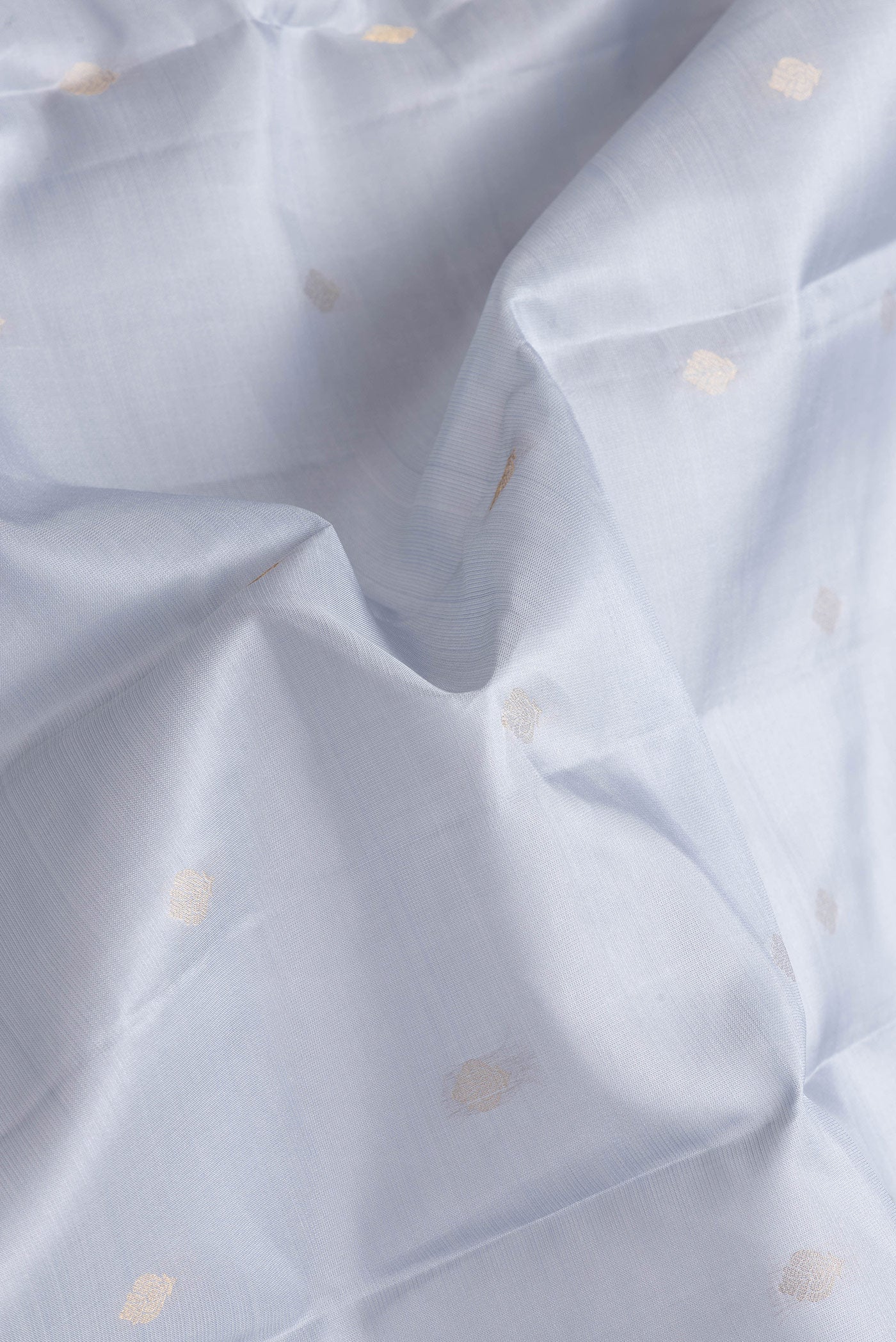 Close up of Grey Dual Tone Kanchipuram Silk Saree with Zari Butta on the body and Zari Border.  displaying folds