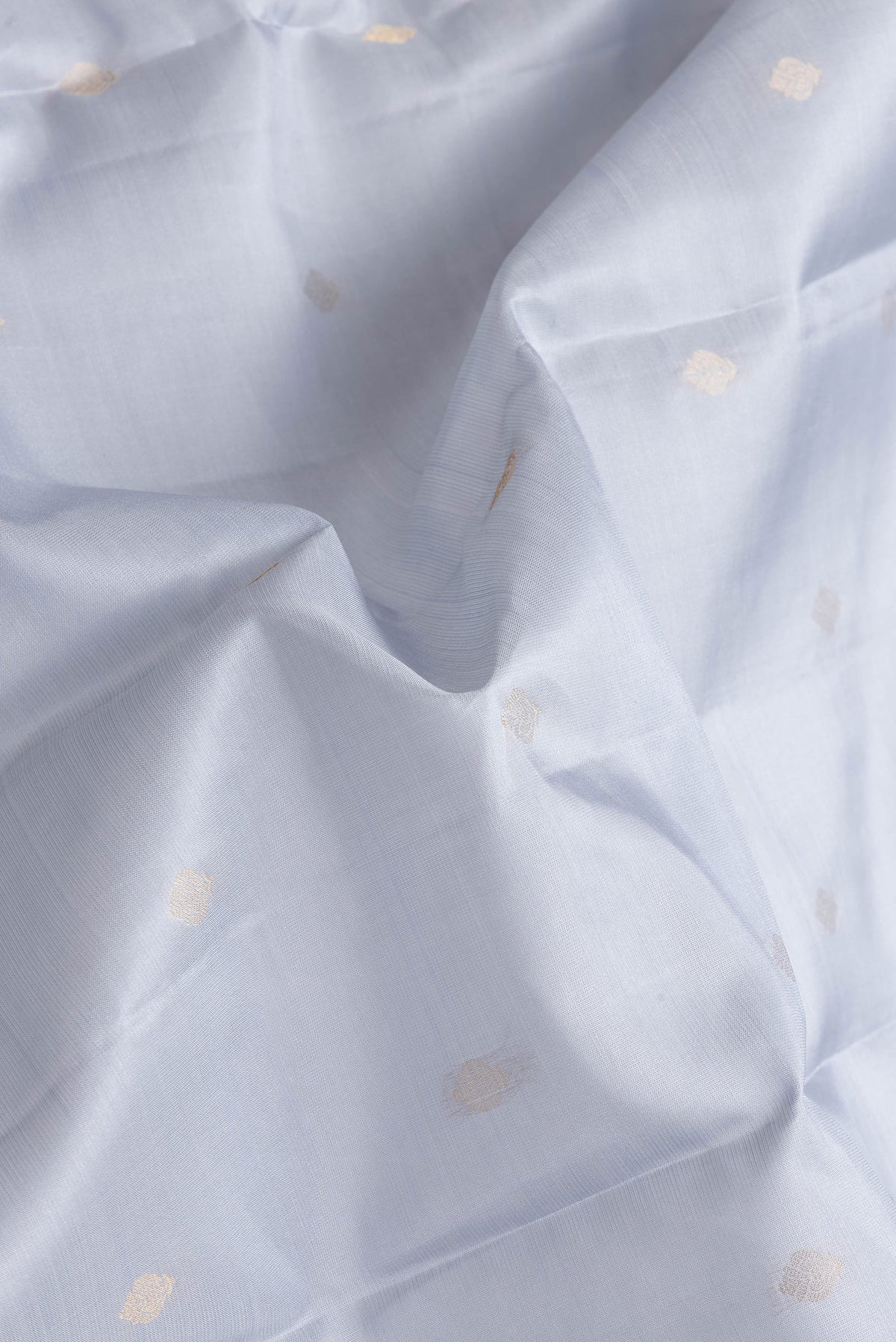 Close up of Grey Dual Tone Kanchipuram Silk Saree with Zari Butta on the body and Zari Border.  displaying folds