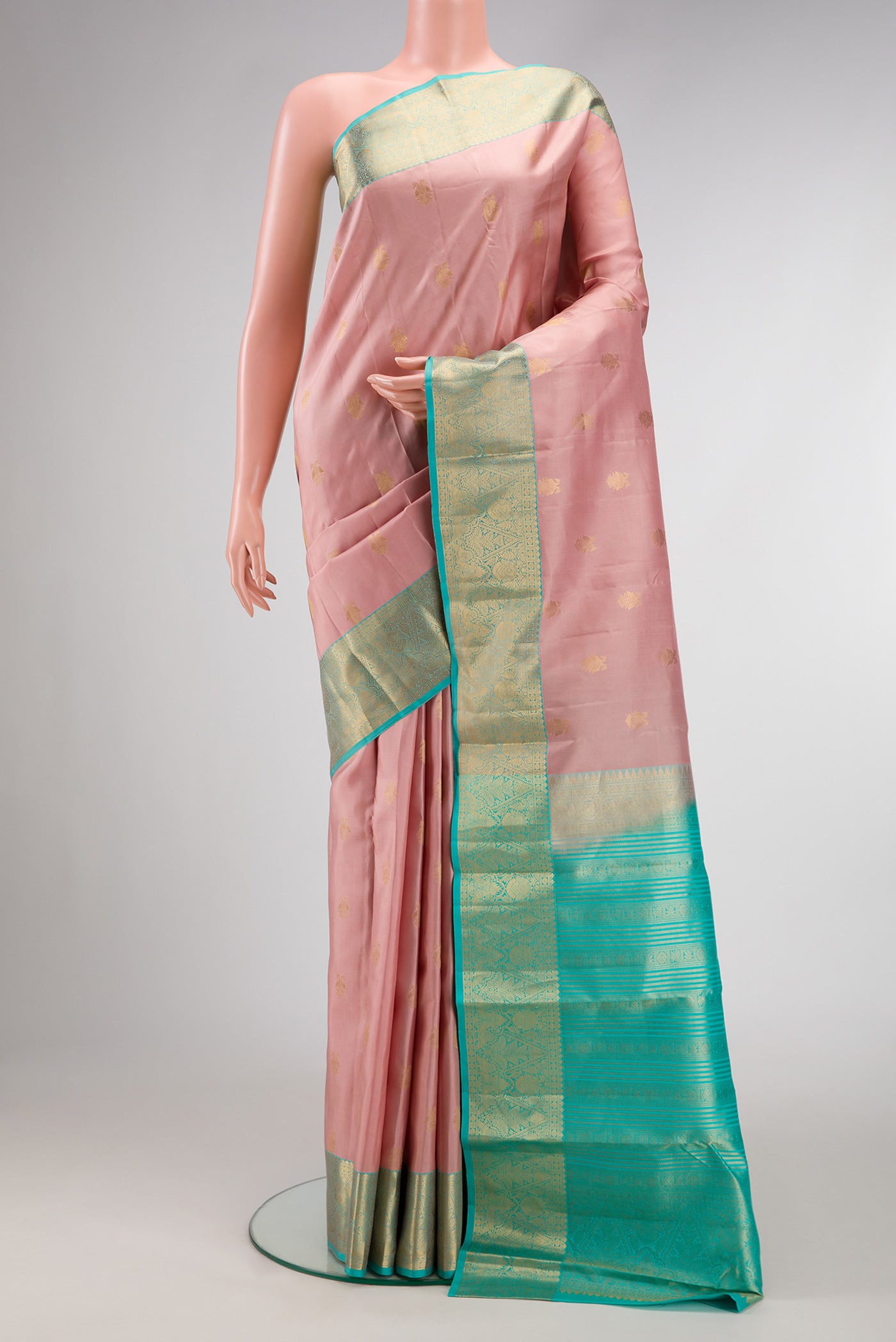 Rose Gold Dual Tone Kanchipuram Silk Saree with Zari Butta on the body and Zari Border.  displayed on a mannequin