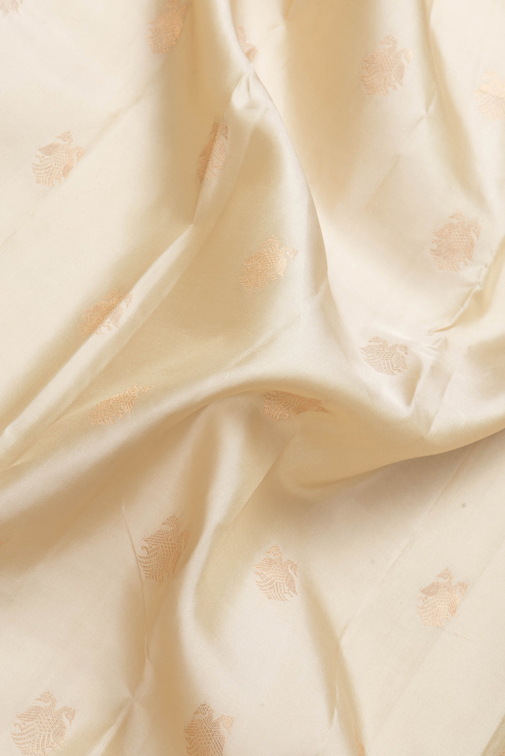 Close up of Beige Dual Tone Kanchipuram Silk Saree with Zari Butta on the body and Zari Border.  displaying folds